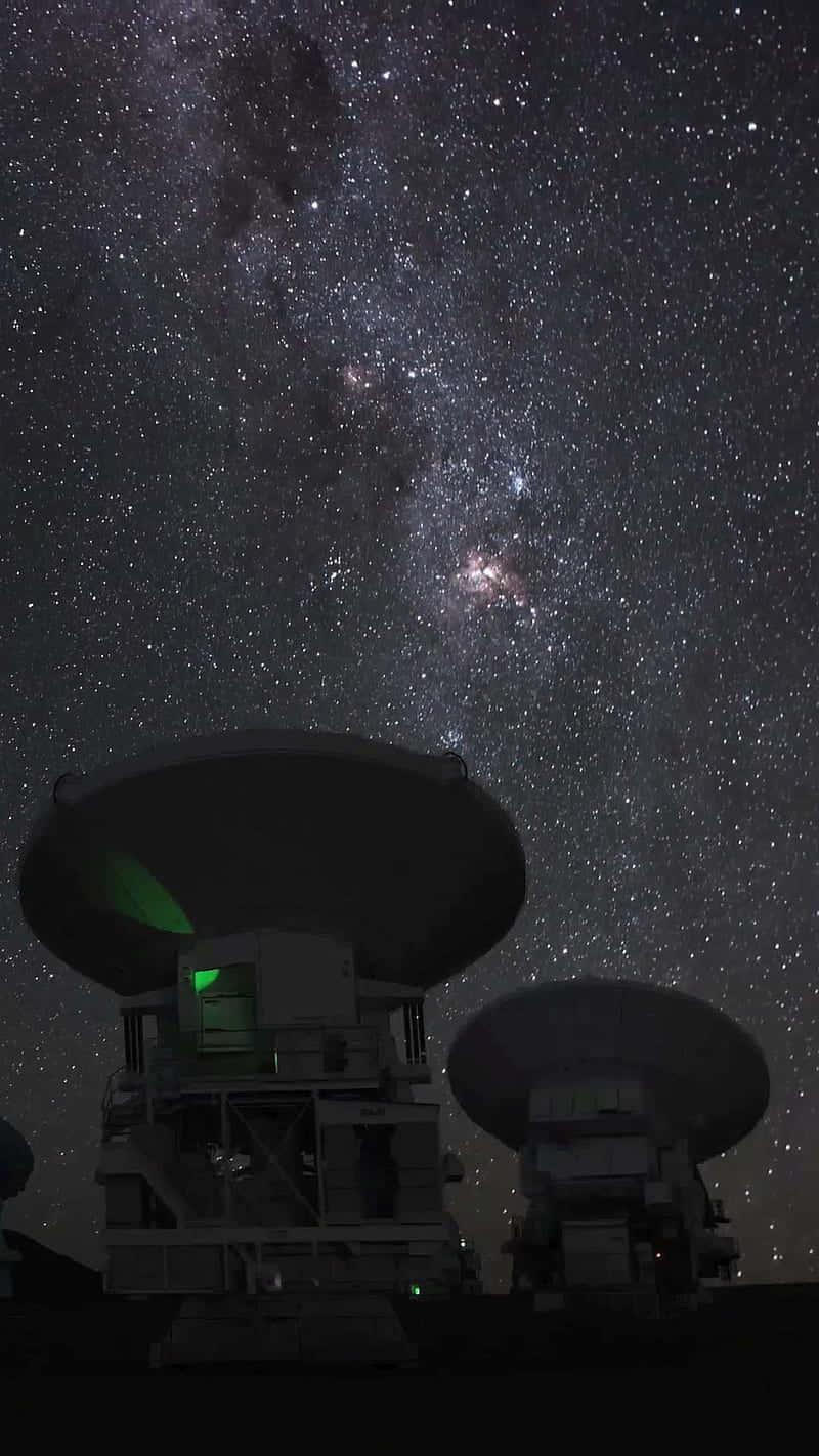  壁紙 — 兩座大型射電望遠鏡在壯麗的星空下呈現剪影，天空中充滿了銀河系發光的核心。