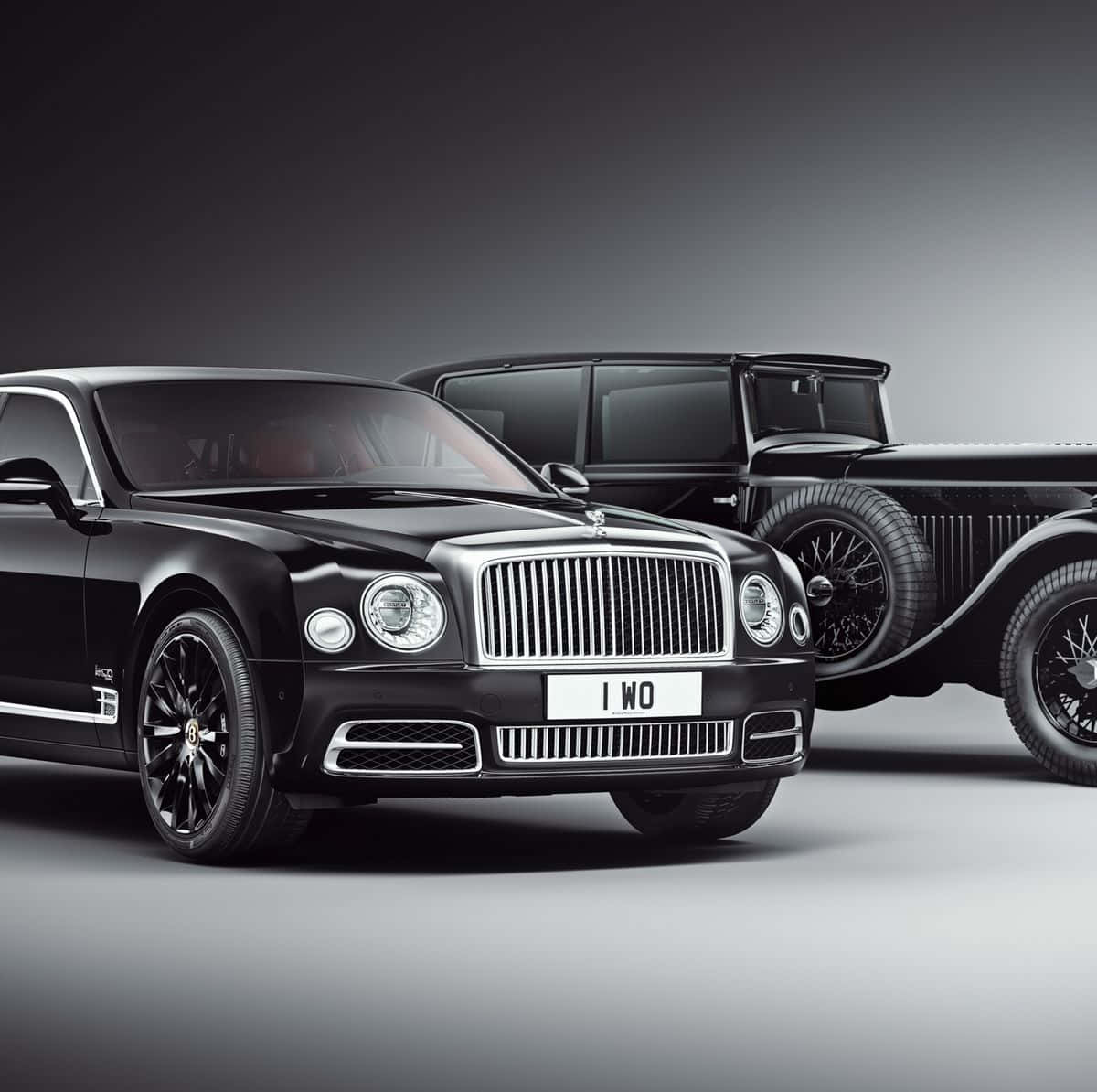 Bentley Mulsanne 桌布 壁紙 — 兩輛時尚的黑色賓利豪華汽車，一輛現代一輛復古，在極簡灰色工作室背景前擺拍。