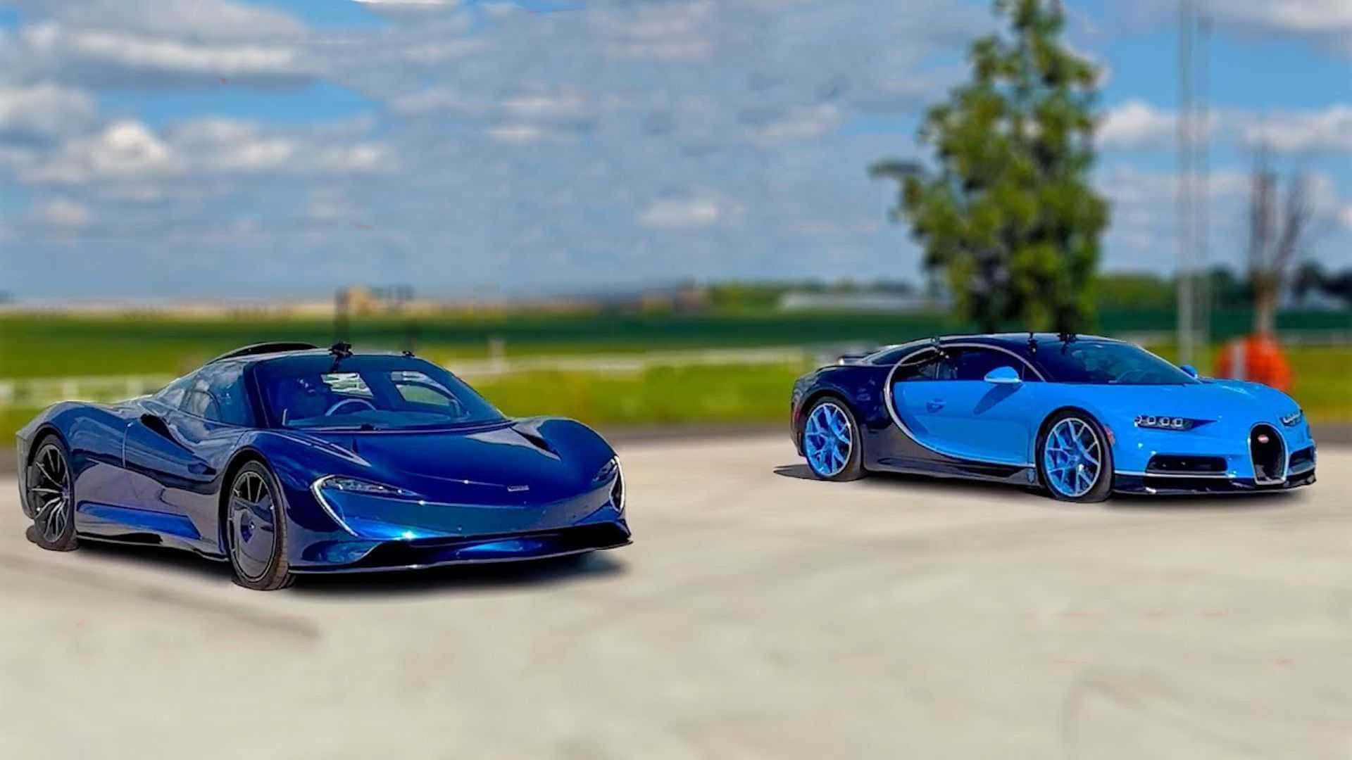 Mclaren Speedtail 桌布 壁紙 — 兩輛時尚的藍色超跑停泊在賽道上，背景是明亮的陰天和綠色田野。