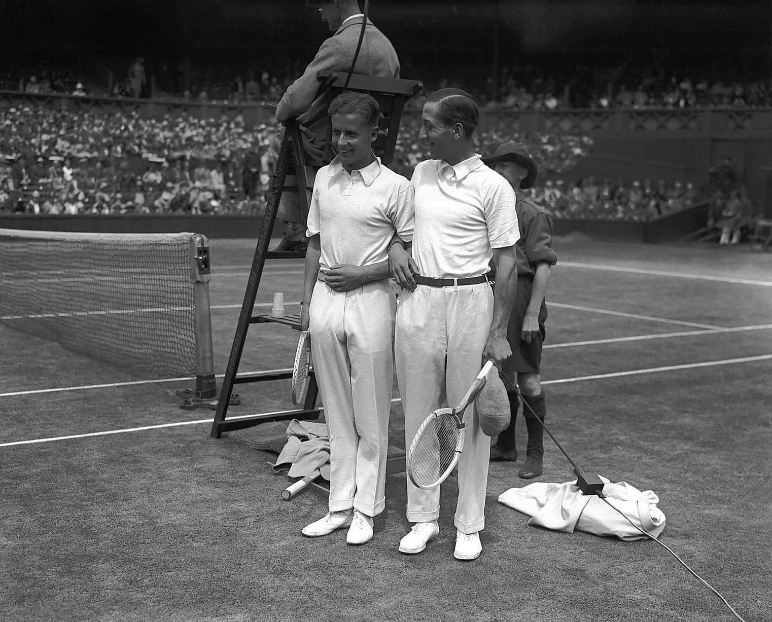 René Lacoste 與 Bunny Austin 合影 壁紙 — 兩名身穿白色制服嘅復古網球選手喺草地場上手挽手，背景有群眾。