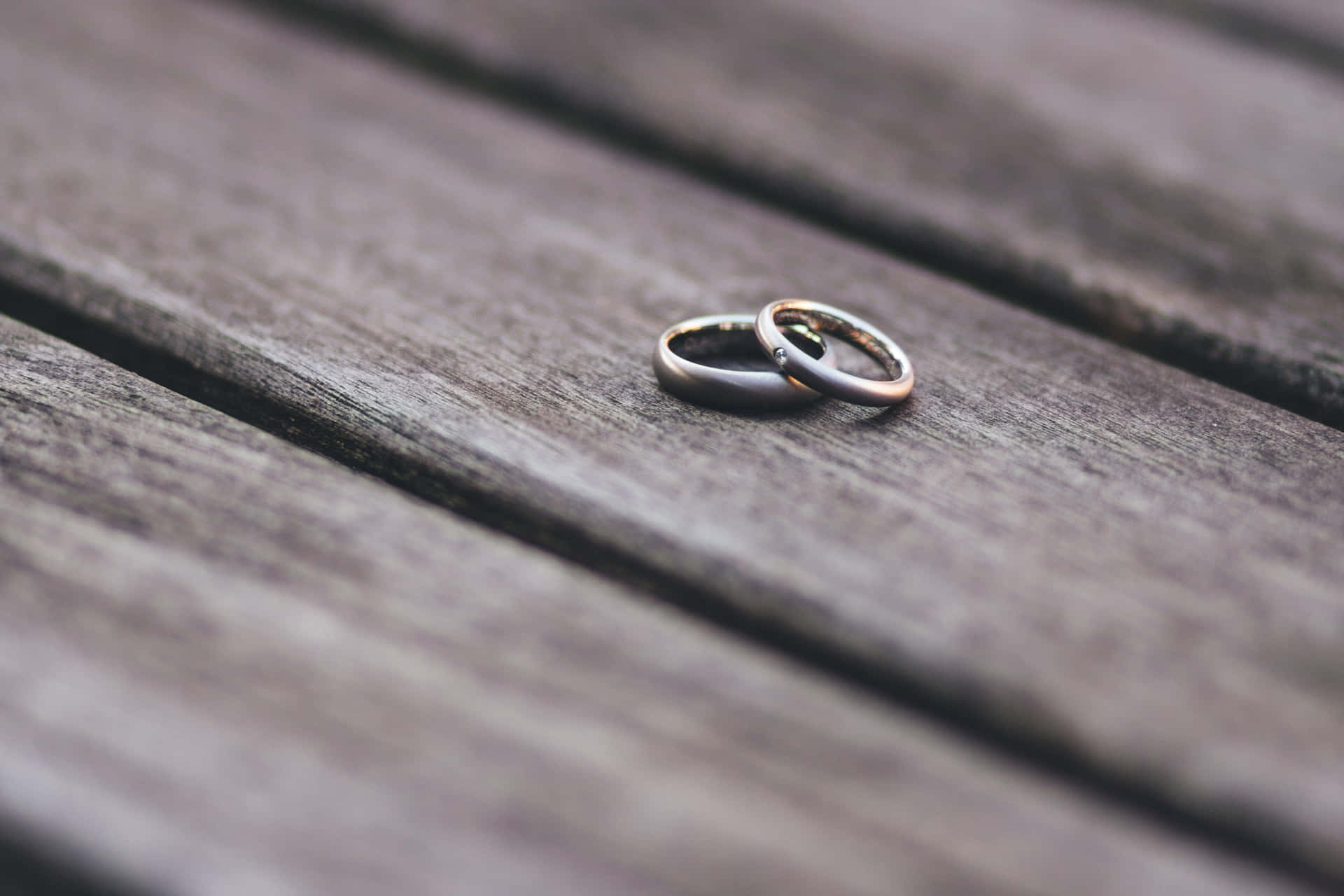 兩枚結婚戒指一起放在木桌上。