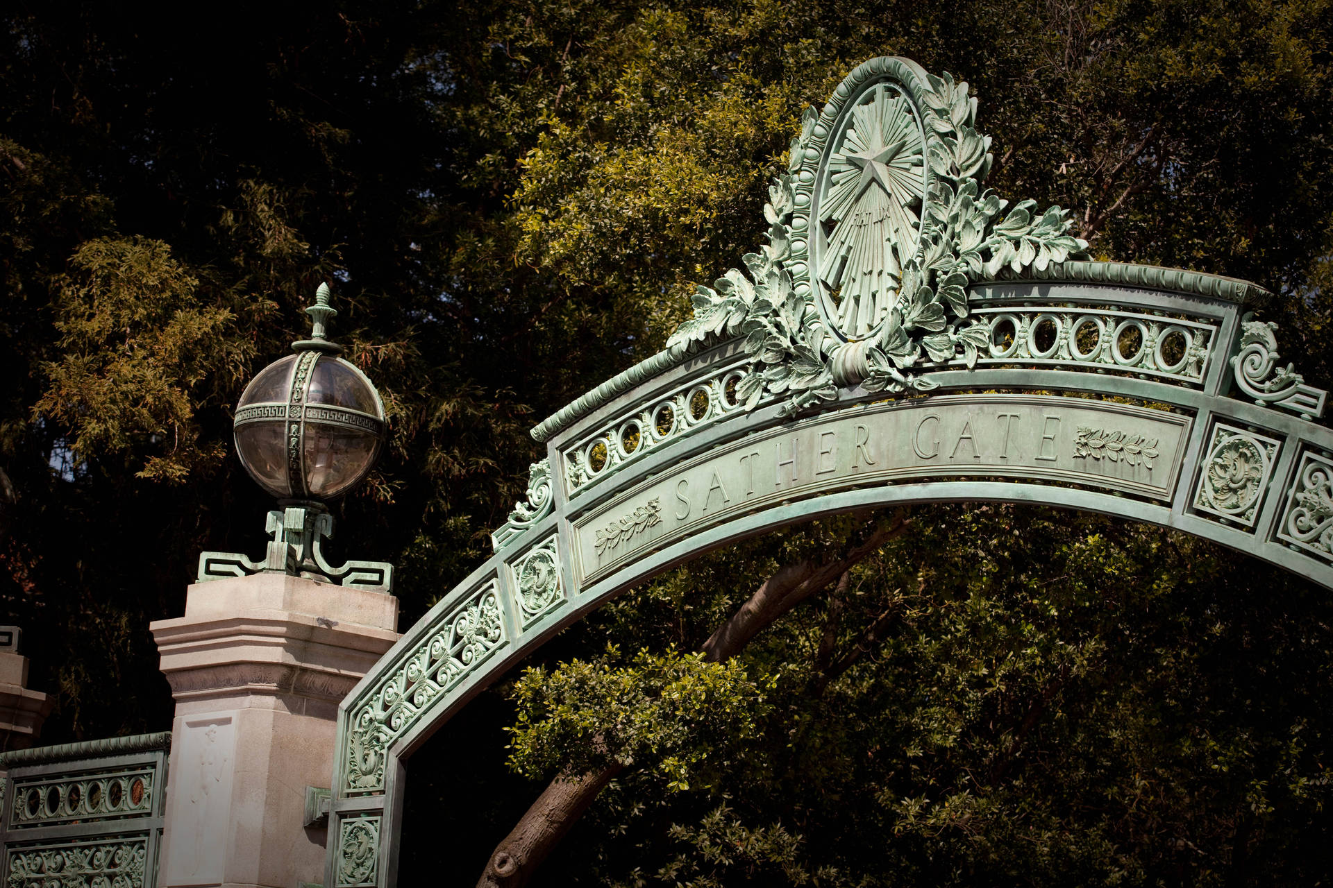 Sather Gate 裝飾華麗的金屬拱門，在校園內被樹木環繞。