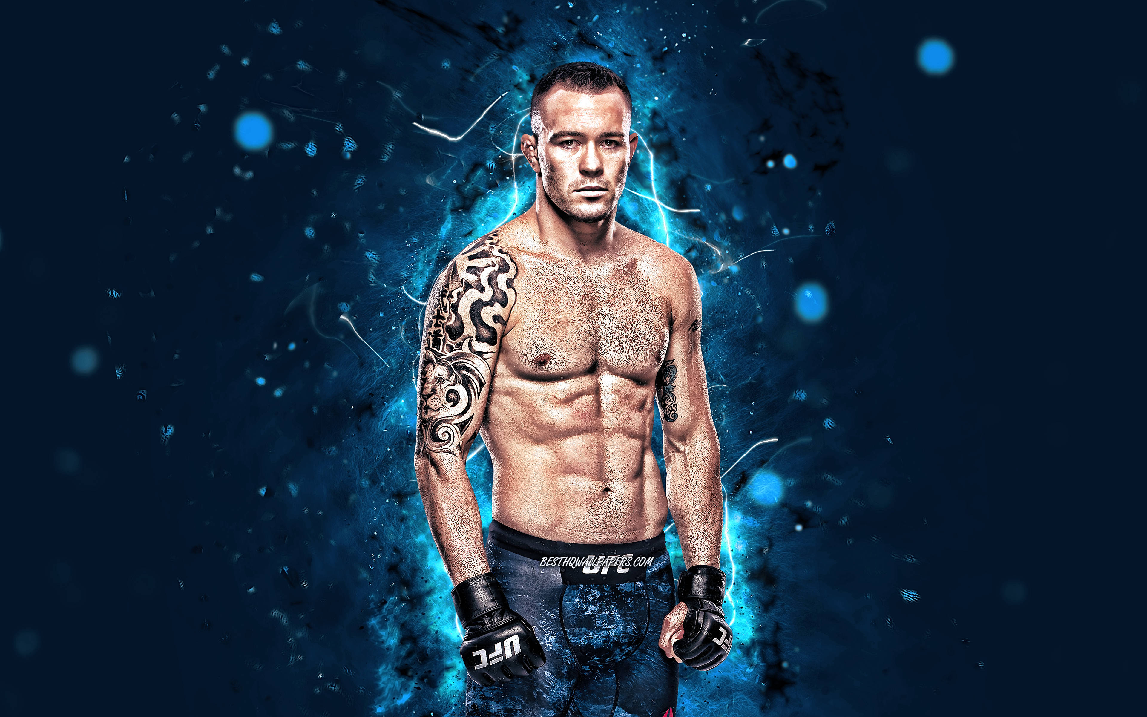 科爾比·科維頓 UFC 4K 霓虹藍 壁紙 — 一個肌肉發達、帶有部落紋身的戰士，在黑暗背景下站在電藍色能量中，戴著UFC手套。