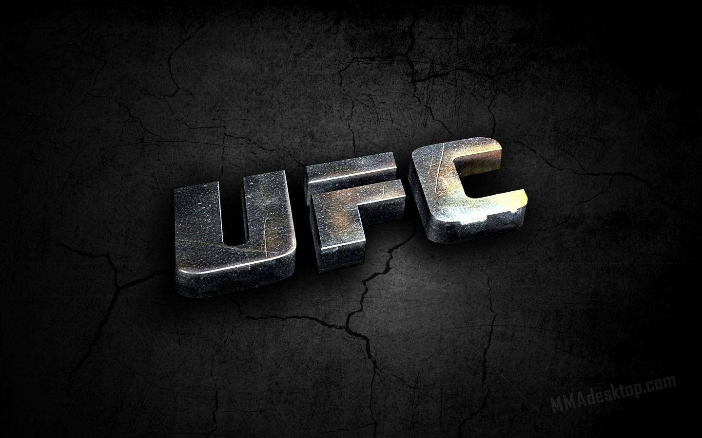 UFC 混合格鬥標誌 壁紙 — 粗糙的金屬UFC標誌放置在裂開的深色牆壁上，戲劇性的燈光突顯其堅韌的質感。
