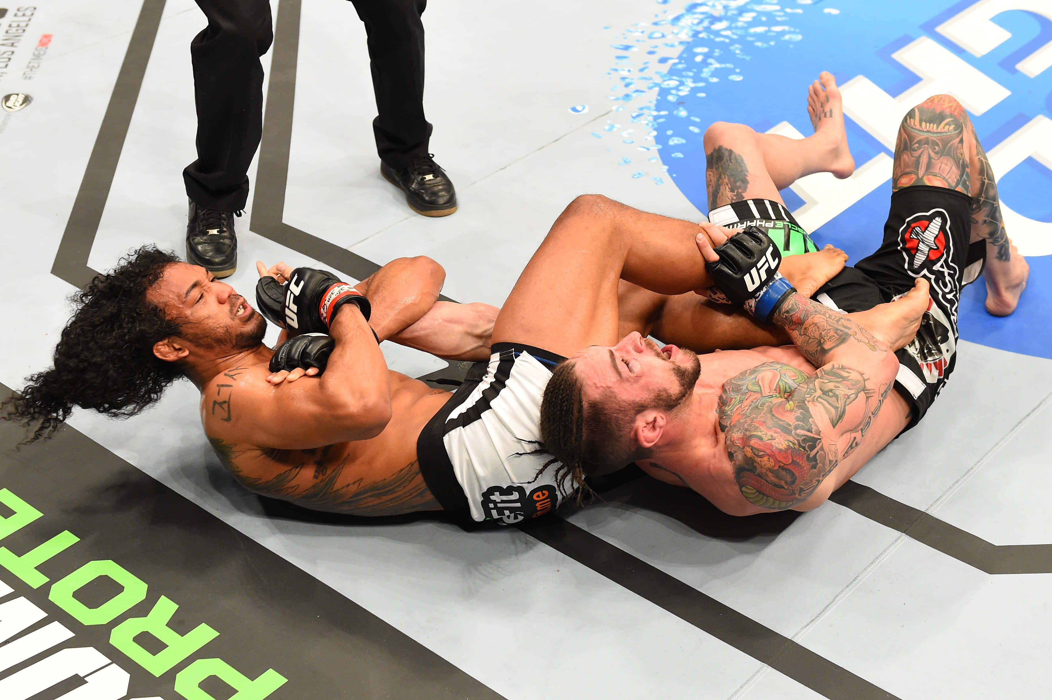 UFC Fight Night 60 本·亨德森對戰薩斯 壁紙 — 兩名紋身MMA拳手在明亮的場館燈光下，於UFC八角籠墊上激烈纏鬥。