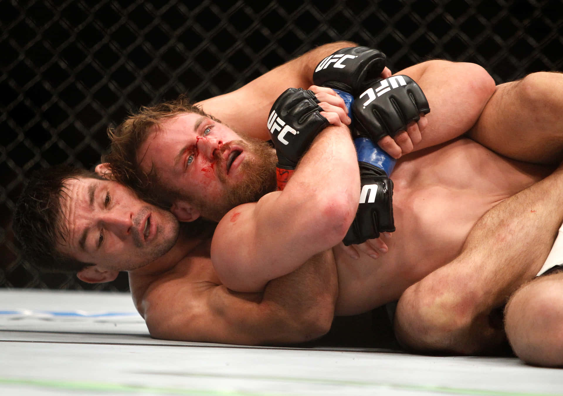 兩名男性MMA拳手在UFC八角籠內的比賽中被鎖喉鎖住。