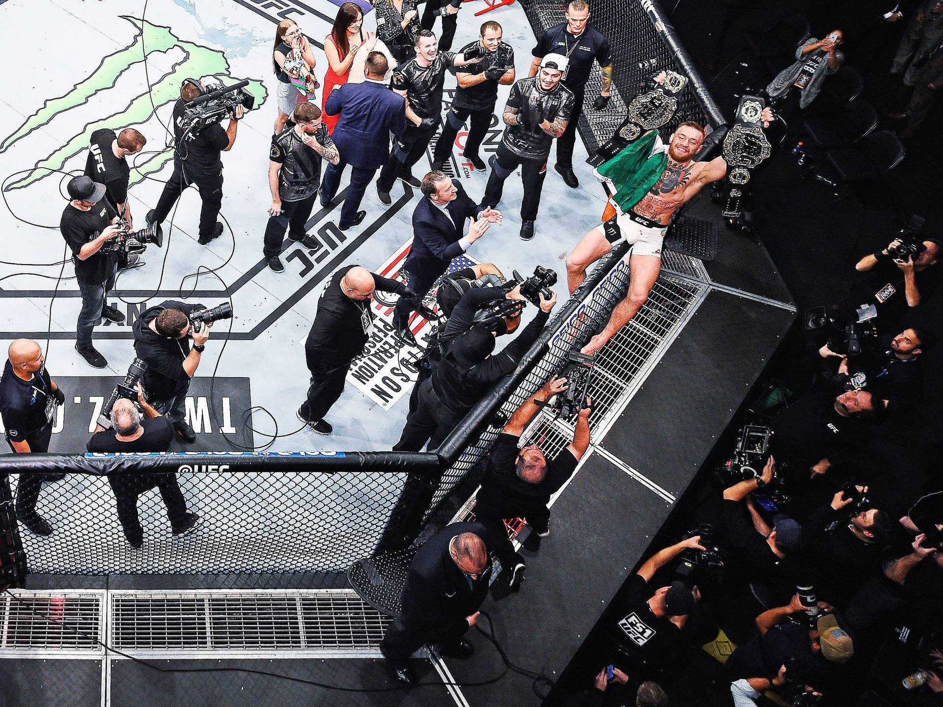 UFC拳手在八角籠中慶祝勝利，攝影師圍繞著他。