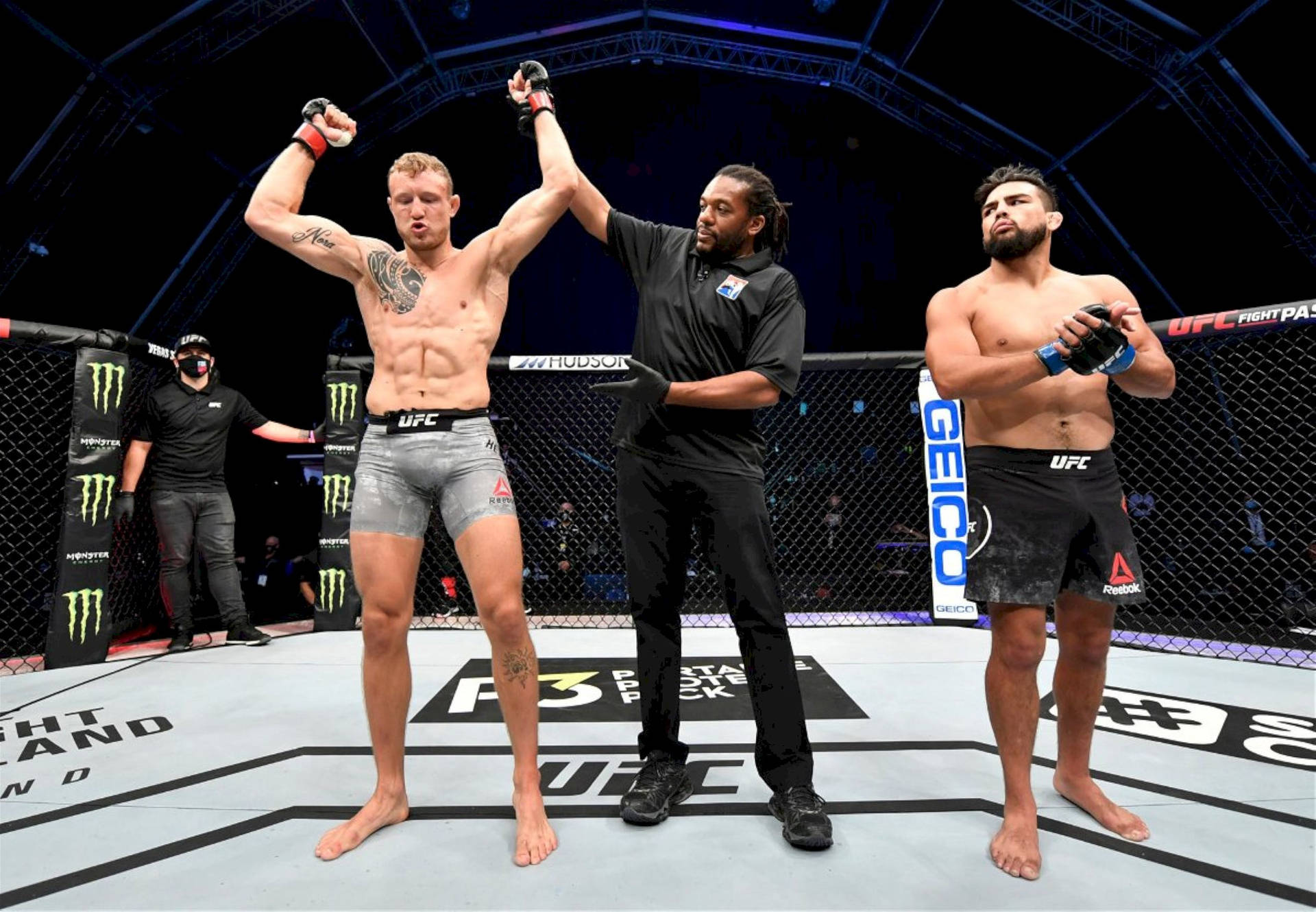 UFC拳手在八角籠中贏得比賽，裁判舉起他的手。
