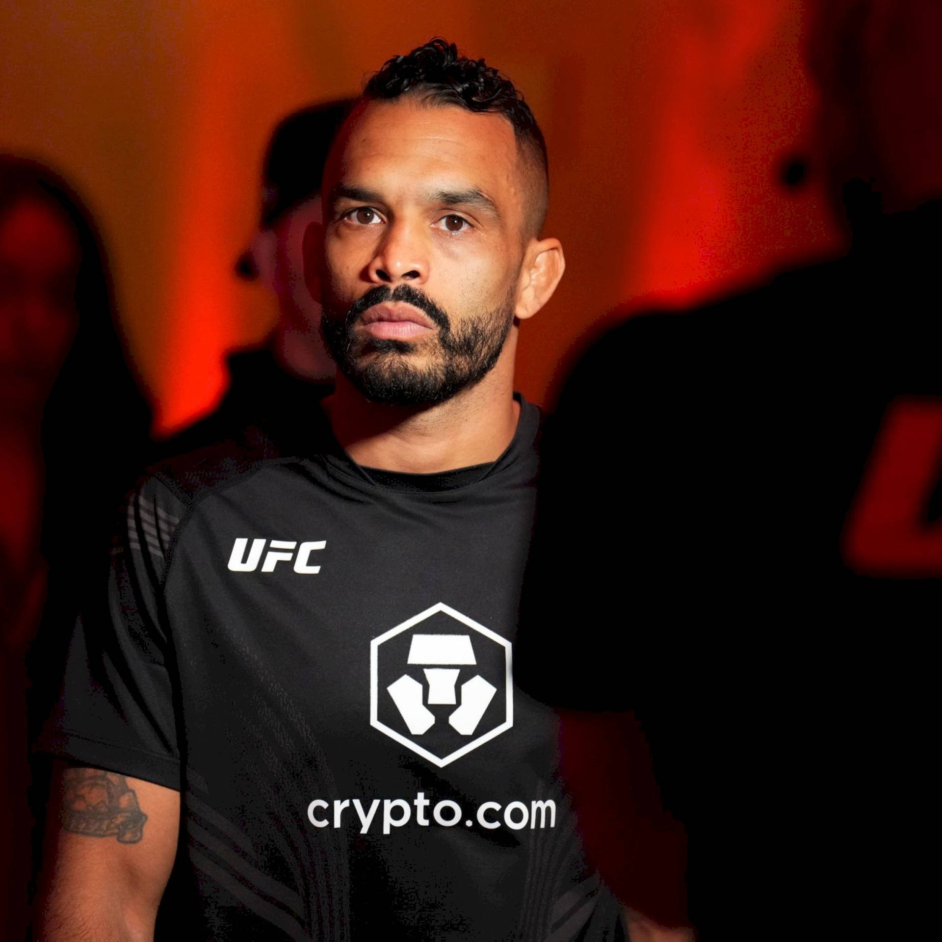 UFC拳手在室內活動中穿著crypto.com襯衫，處於紅燈下