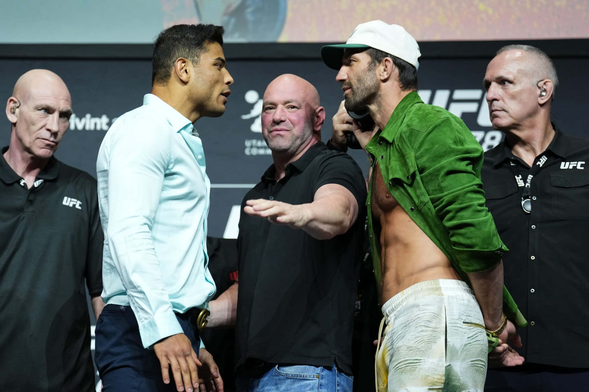 UFC選手保羅·科斯塔與盧克·羅克霍德2022記者會 壁紙 — 兩名UFC拳手在稱重儀式上對峙，官員在兩旁，場館燈光璀璨。
