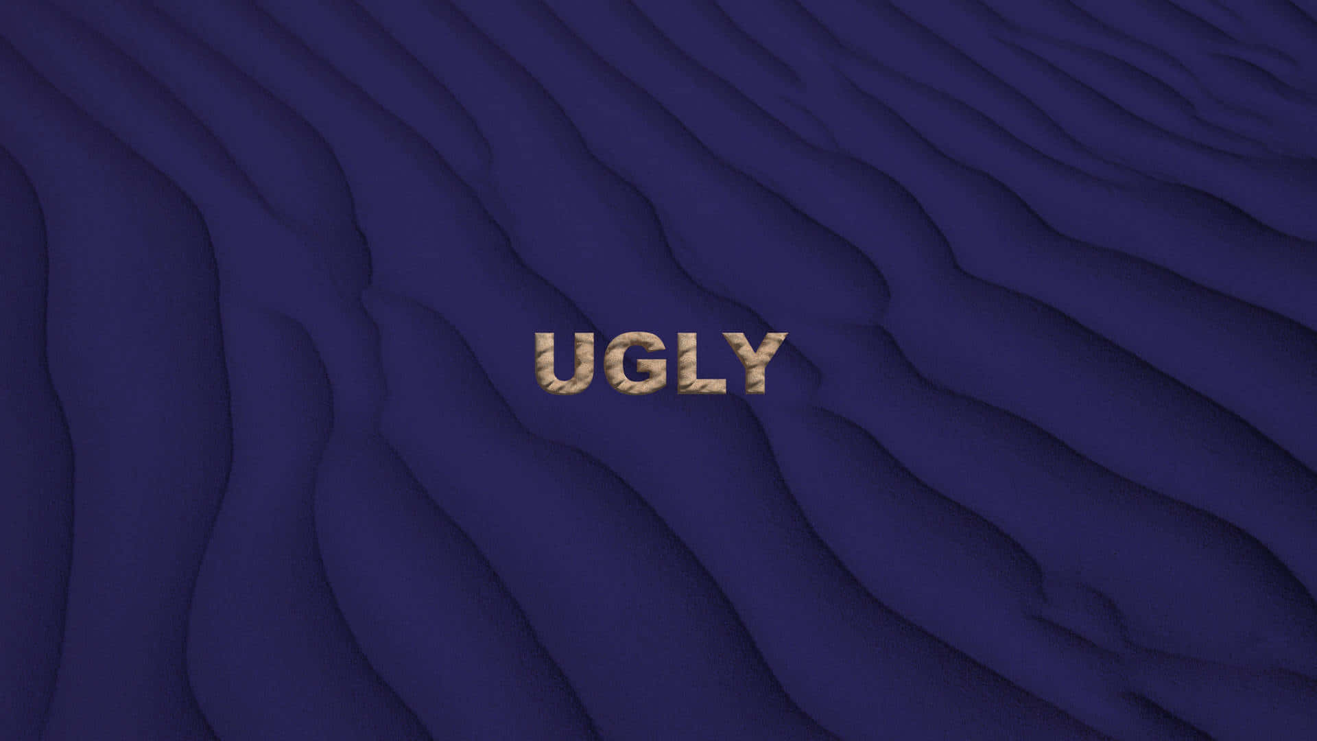 醜樣 桌布 壁紙 — 「ugly」一詞以帶紋理的金色字母呈現，置於帶柔和陰影的深藍色波浪表面上。