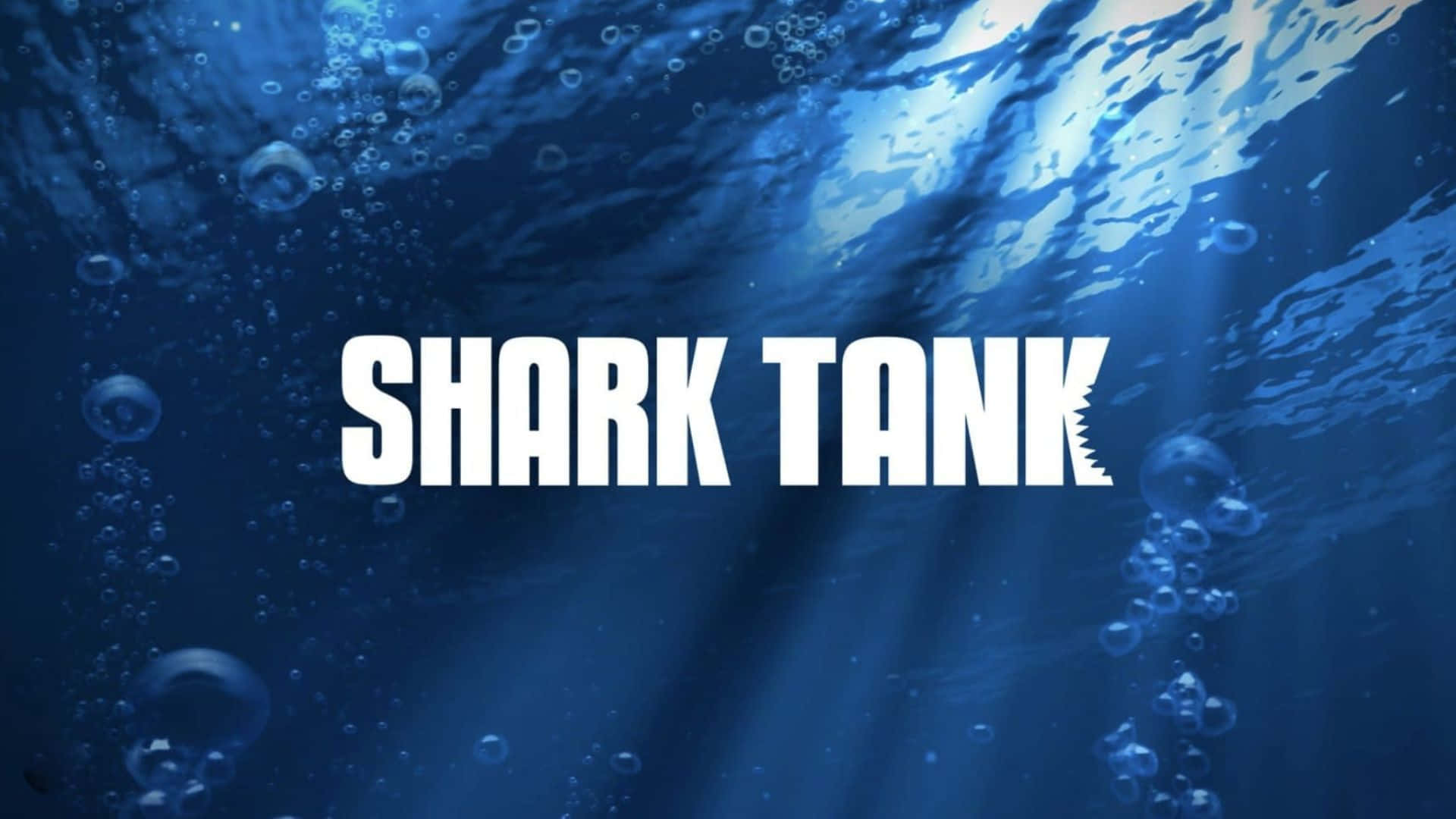  壁紙 — 水下藍色場景，有陽光射線和氣泡，帶有粗體白色「SHARK TANK」文字，並在「K」上有鋸齒狀鯊魚鰭。