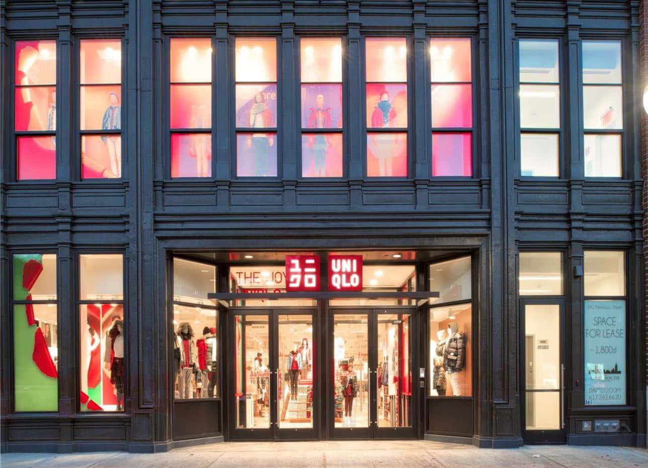 夜晚中UNIQLO店舖正面，櫥窗亮起燈光，展示人體模型。