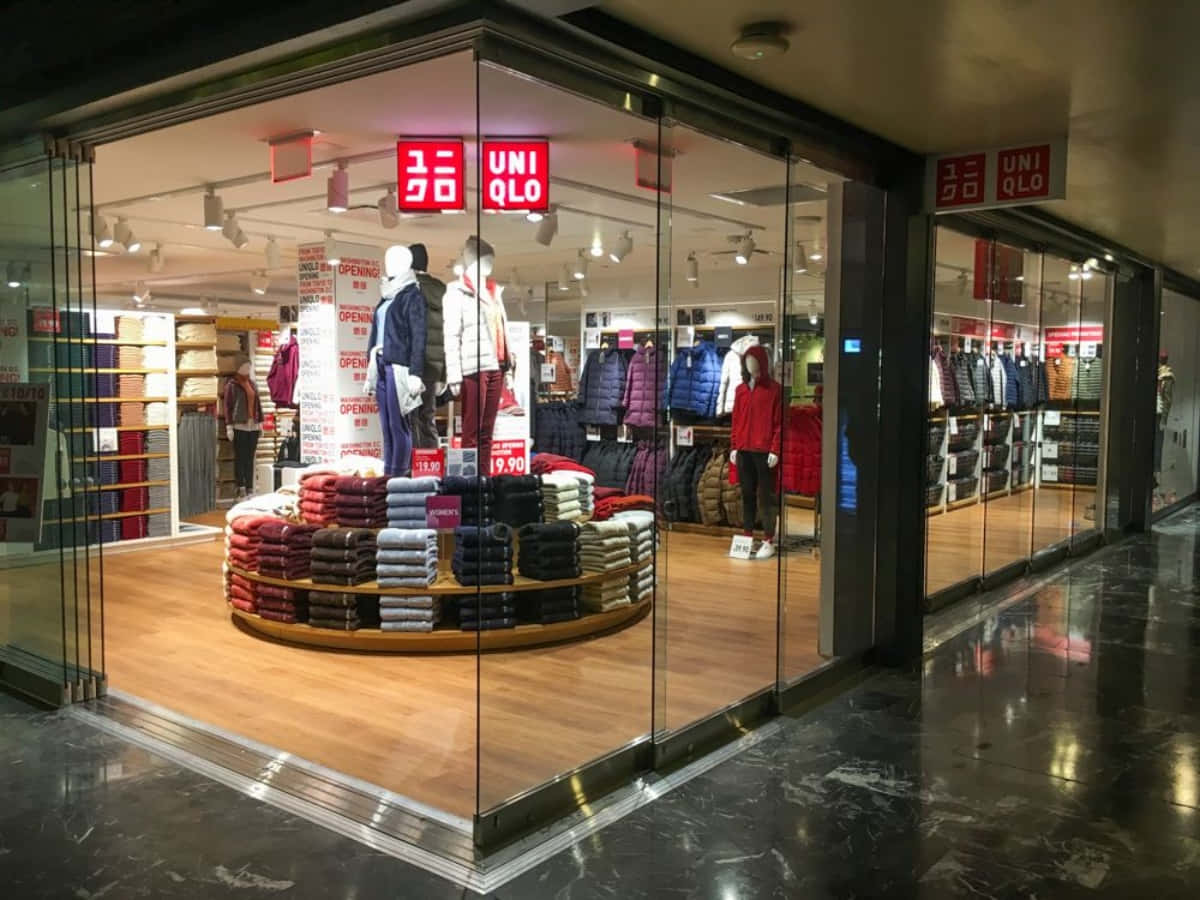 Uniqlo商店櫥窗，展示人體模型和木架上的摺疊衣物。