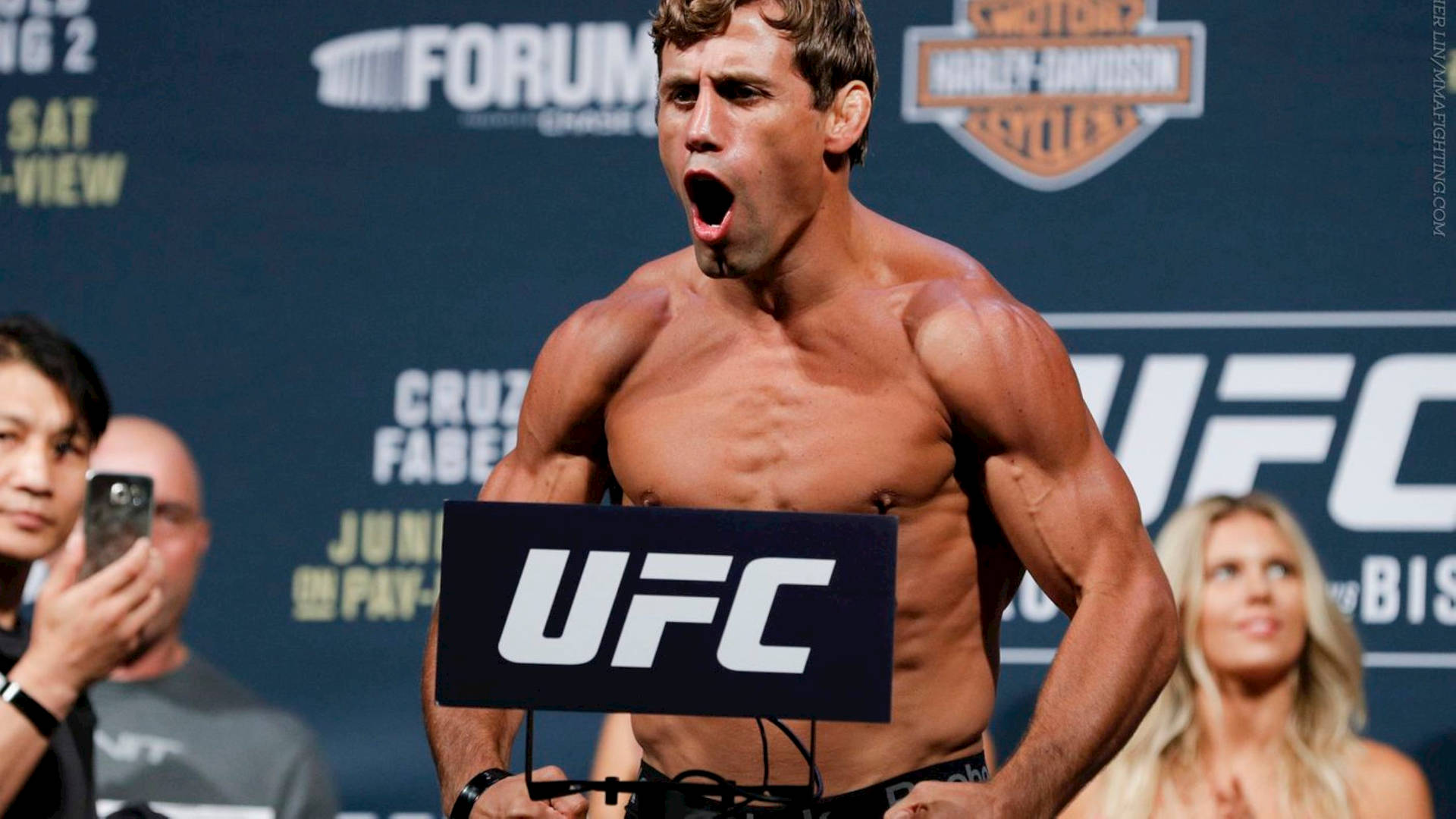一名赤裸上身的UFC格鬥家在稱重活動中咆哮。