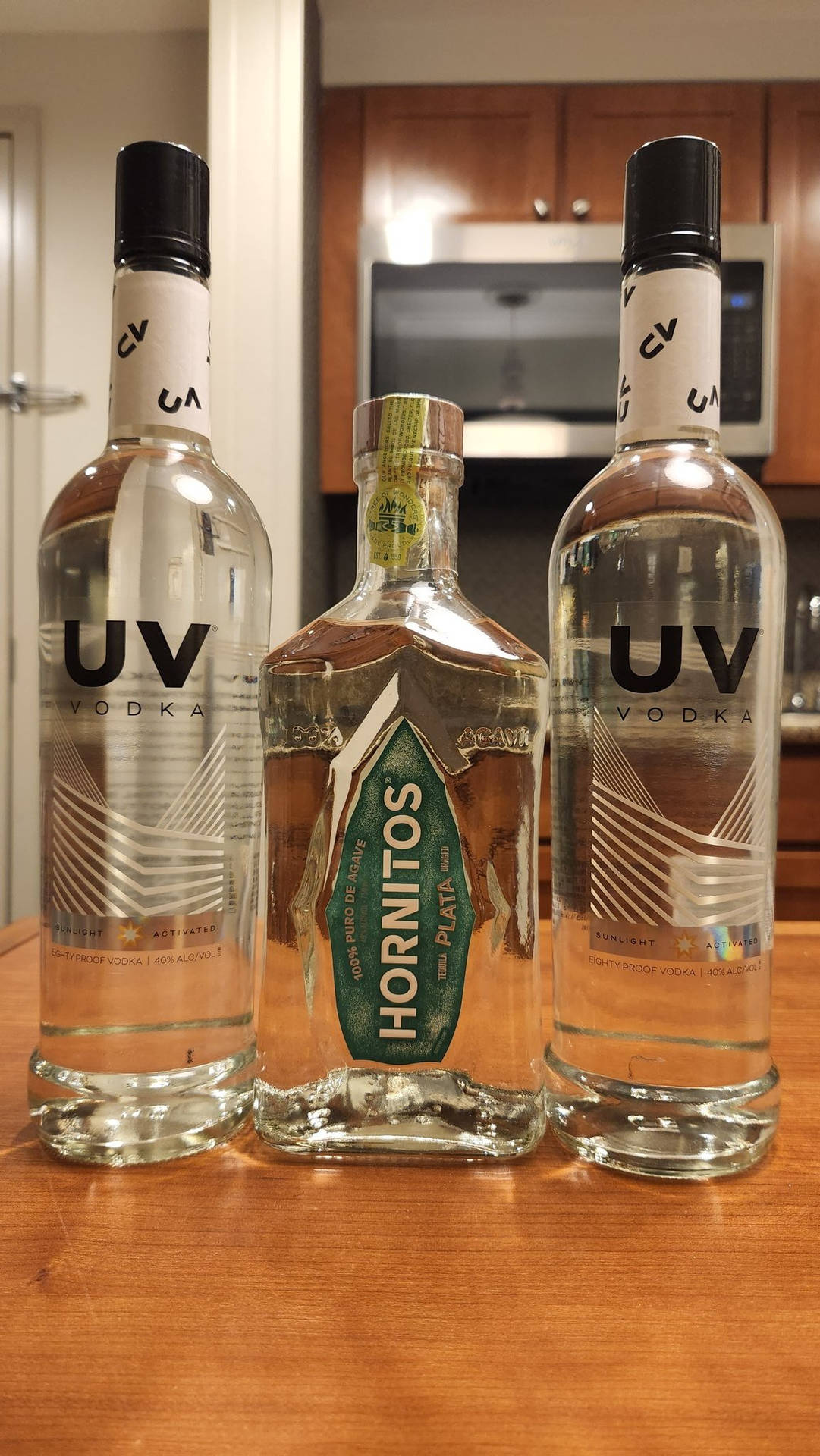 木製廚房枱面上的三瓶伏特加酒