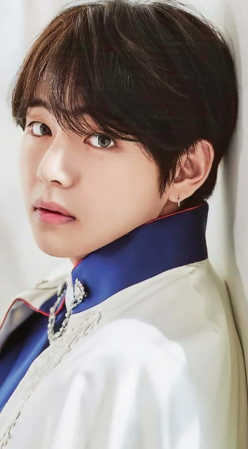 時尚造型的 V BTS 手機版 壁紙 — 一個年輕黑髮淺色眼睛男子的特寫肖像，穿著帶有銀色刺繡的白色和藍色傳統風格外套。