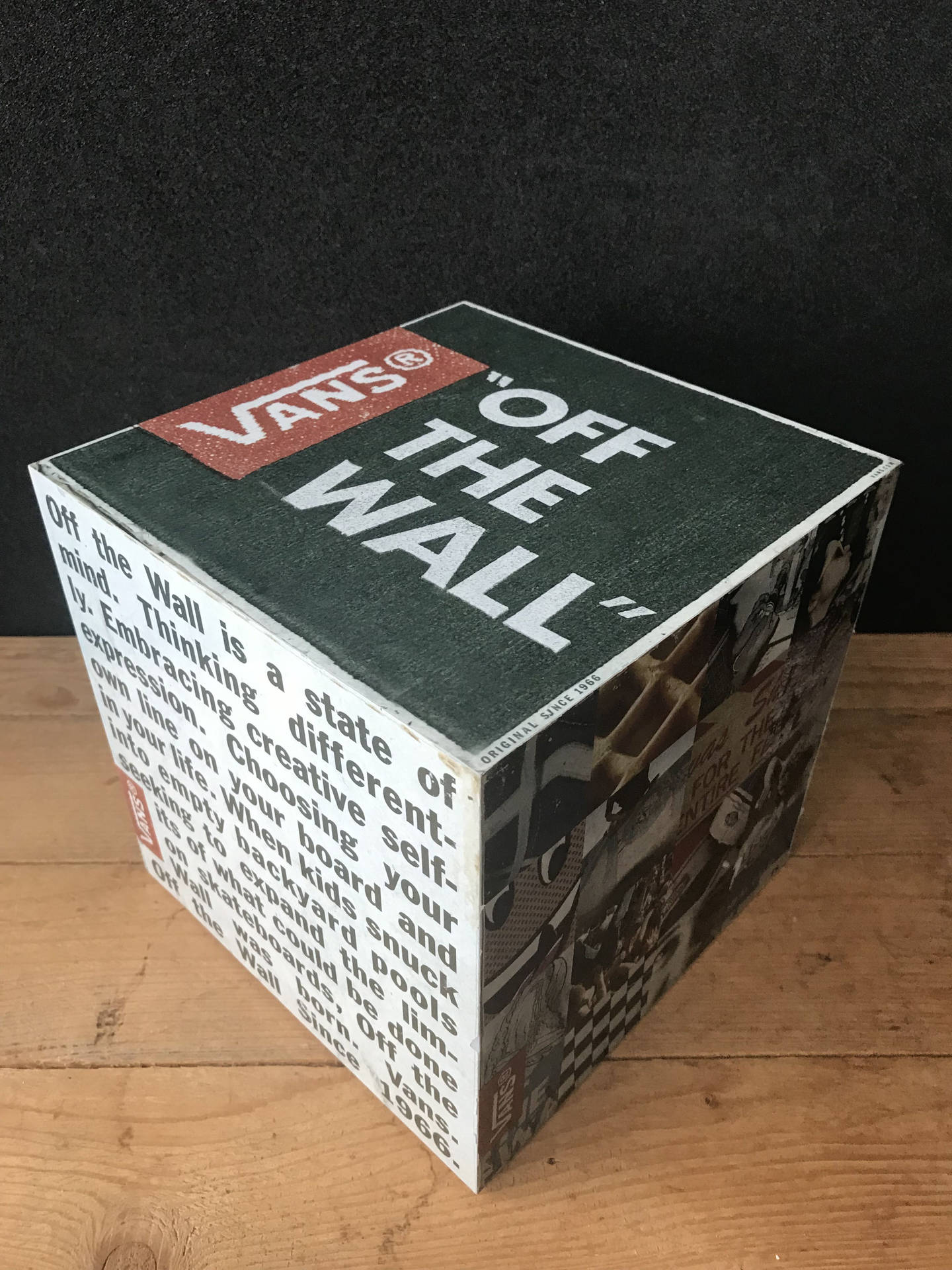 一個 Vans 品牌立方體，帶有 'Off The Wall' 標語和滑板圖形在木頭上。