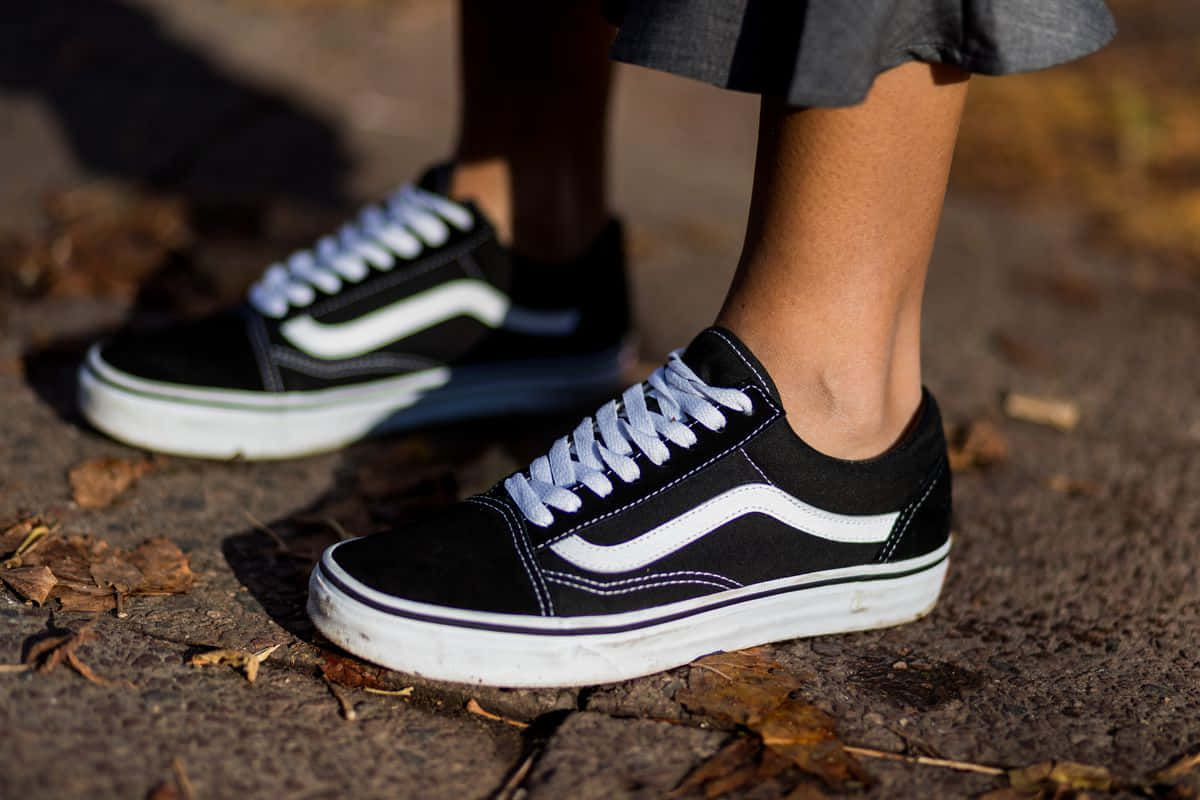 Vans Old Skool - 一位女性穿著黑白運動鞋 壁紙