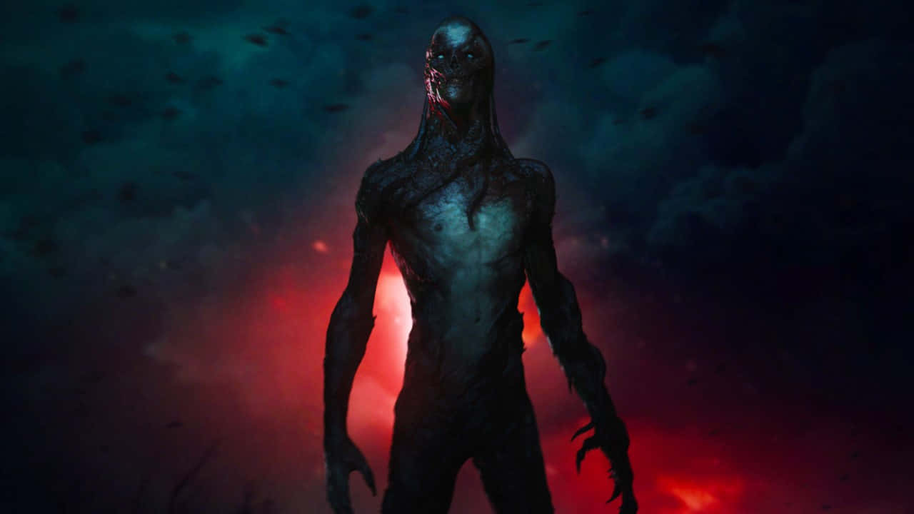 《怪奇物語》Vecna 人形怪物 壁紙 — 一個畸形的類人生物，四肢細長，眼睛發光，站在被火紅和青綠色雲層分割的黑暗天空中。