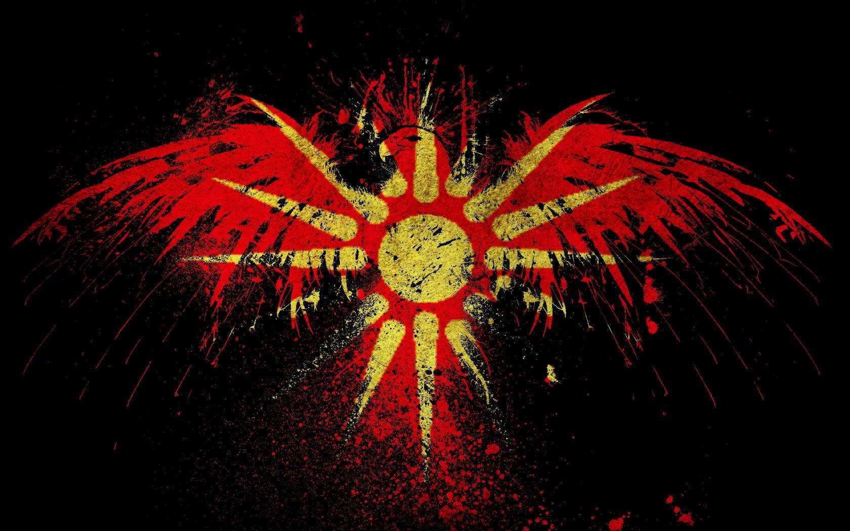 馬其頓 Vergina 太陽與鷹 壁紙 — 一個大膽的紅黃色帶翅膀的太陽在黑色背景上爆發，帶有飛濺的油漆效果。