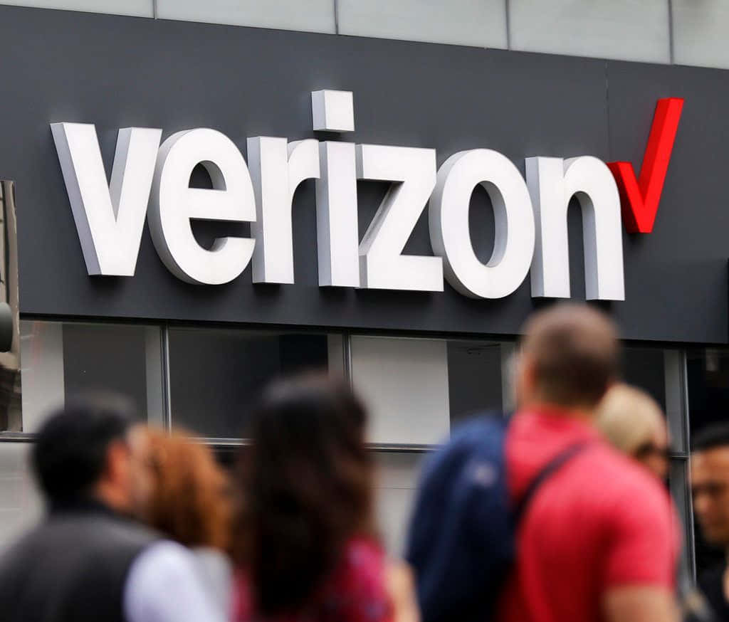 行人走過 Verizon 商店標誌。