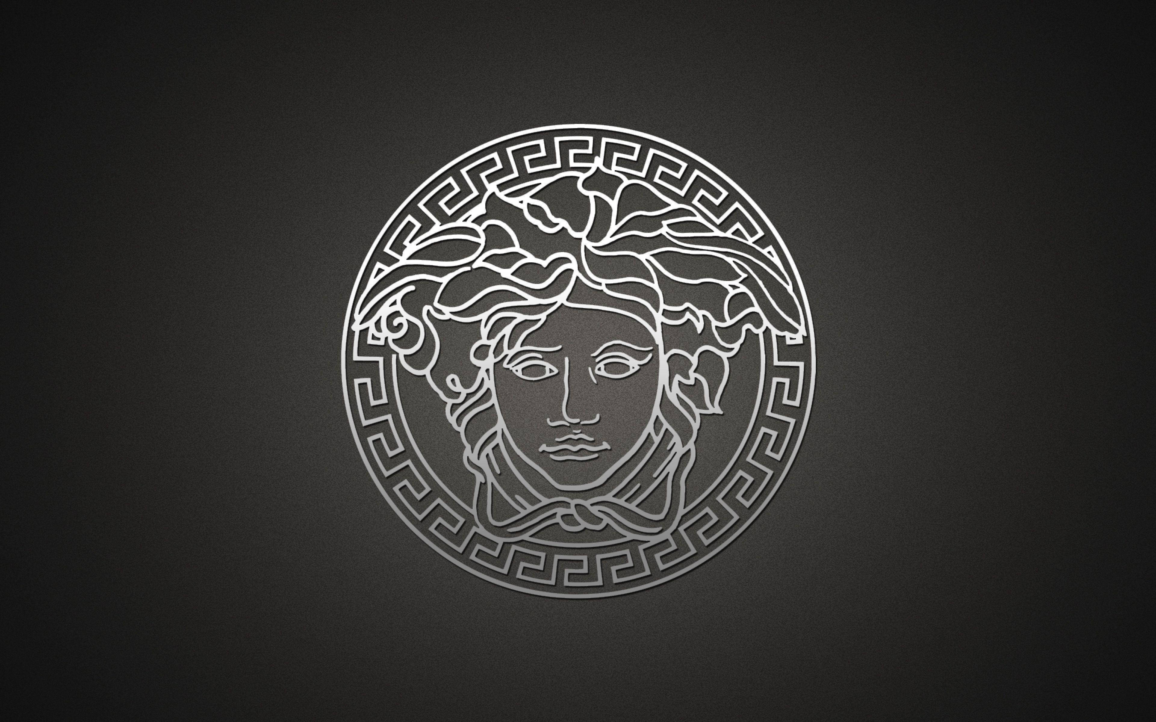 白色陰影 Versace 標誌 壁紙 — 一個極簡風格的銀色美杜莎頭像標誌，帶有希臘鑰匙邊框，居中於深灰色漸變背景上。