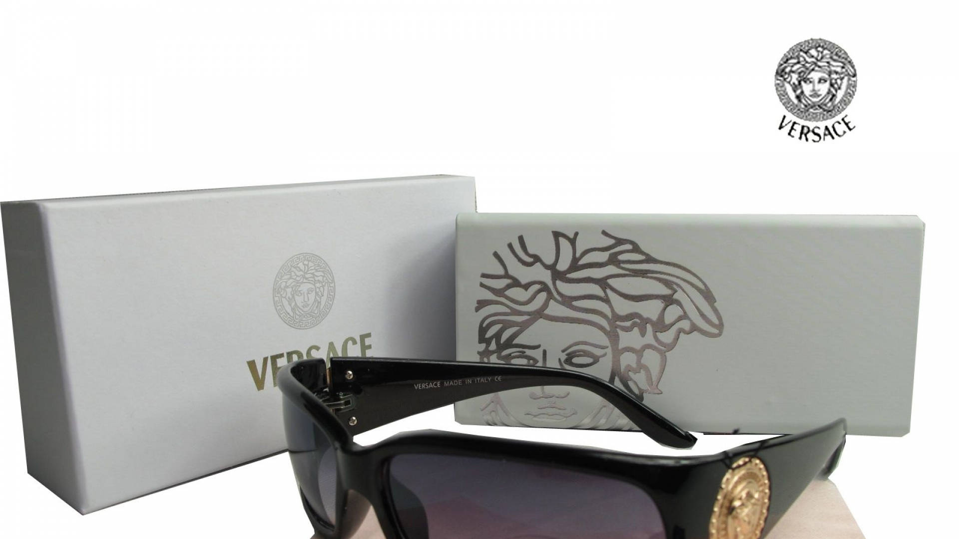 Versace VE4044太陽眼鏡 壁紙 — 黑色 Versace 太陽眼鏡，帶金色美杜莎標誌，展示在品牌白色盒子旁，背景為純白色。