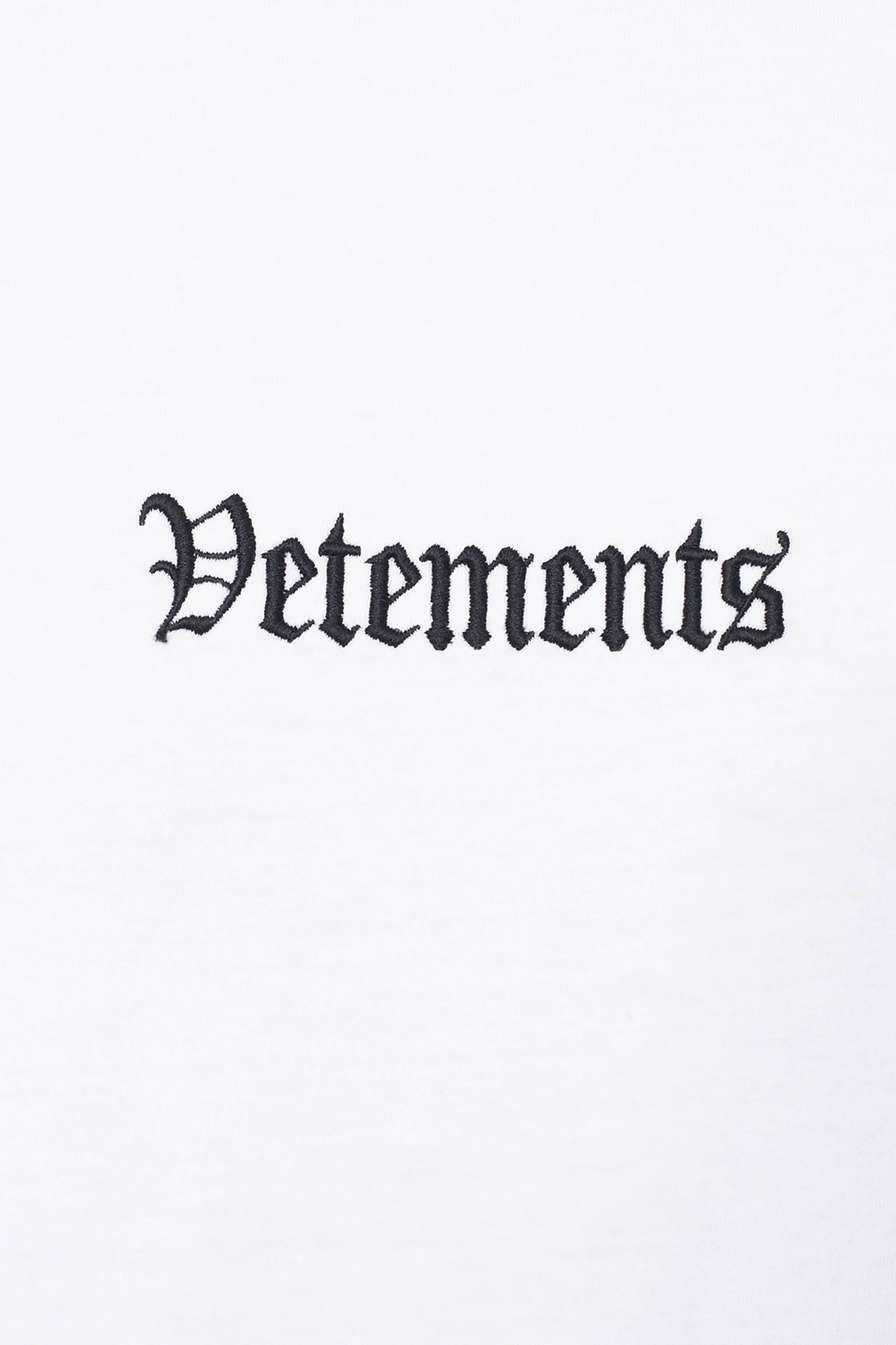 Vetements 白底繡字 壁紙 — 簡約白色背景，中央突出顯示粗體黑色哥德式刺繡的「Vetements」字樣。