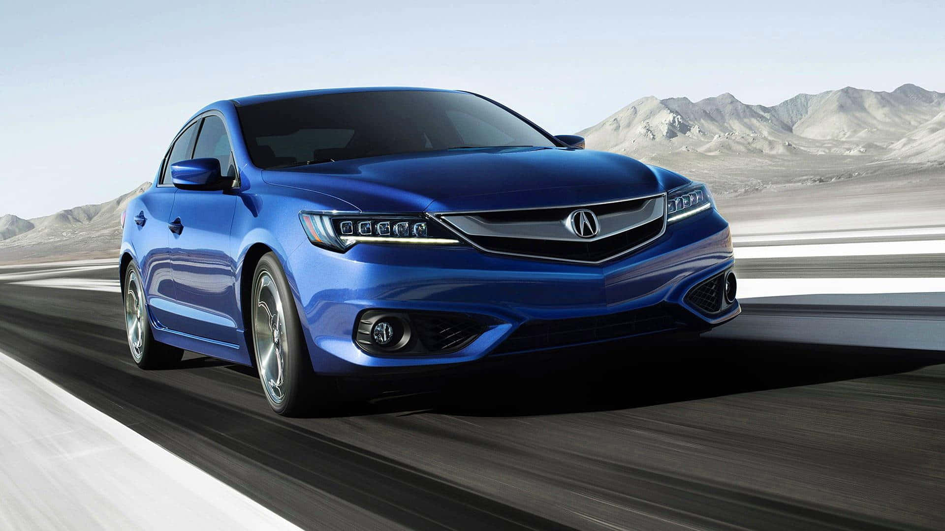 Acura Ilx 桌布 壁紙 — 一輛充滿活力的藍色Acura房車在沙漠高速公路上疾馳，帶有模糊的動態效果，遠山在晴朗的天空下清晰可見。