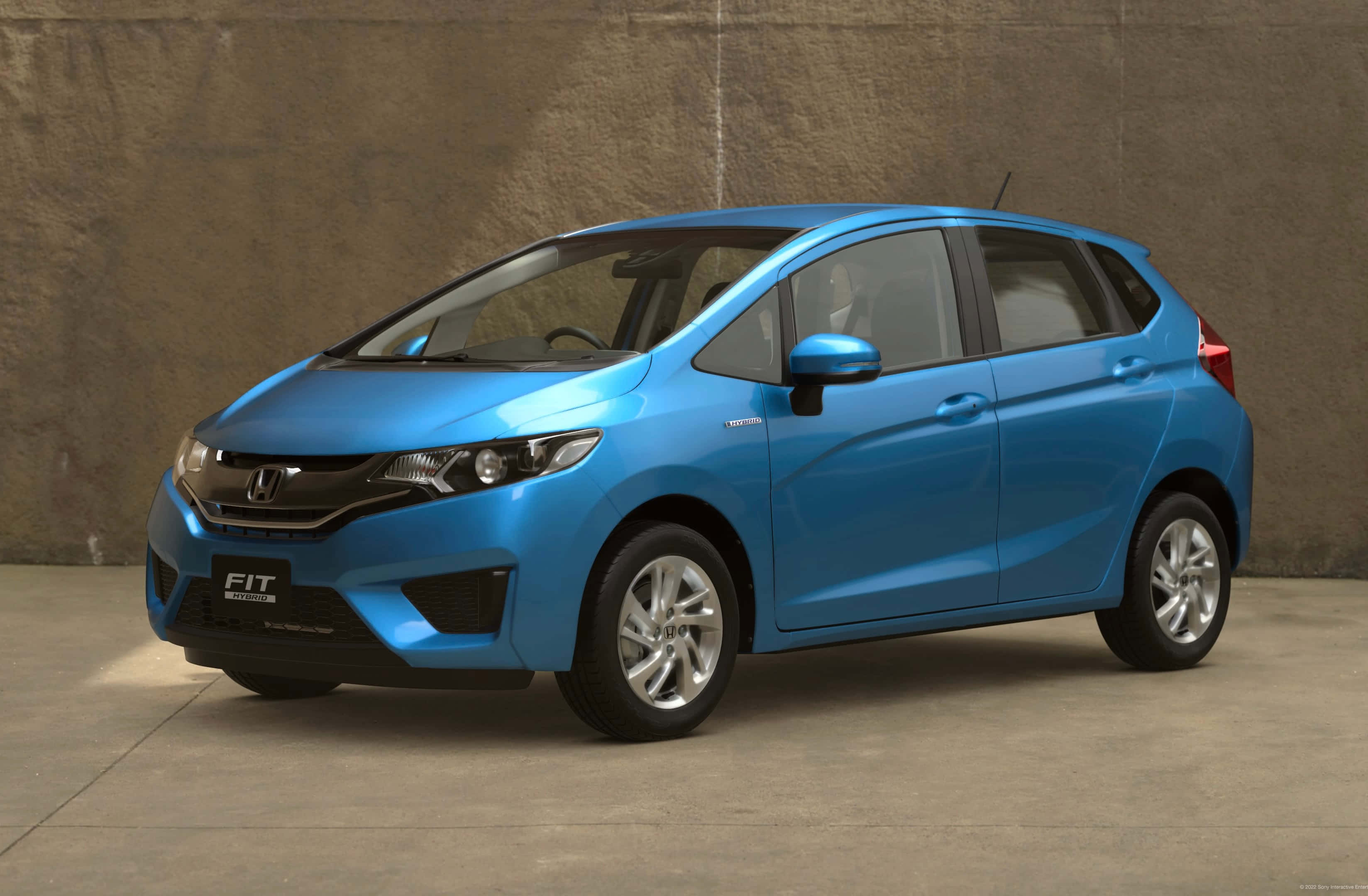 Honda Fit 桌布 壁紙 — 一輛充滿活力的藍色本田飛度混合動力車在工作室中展示，背景是帶紋理的混凝土牆。