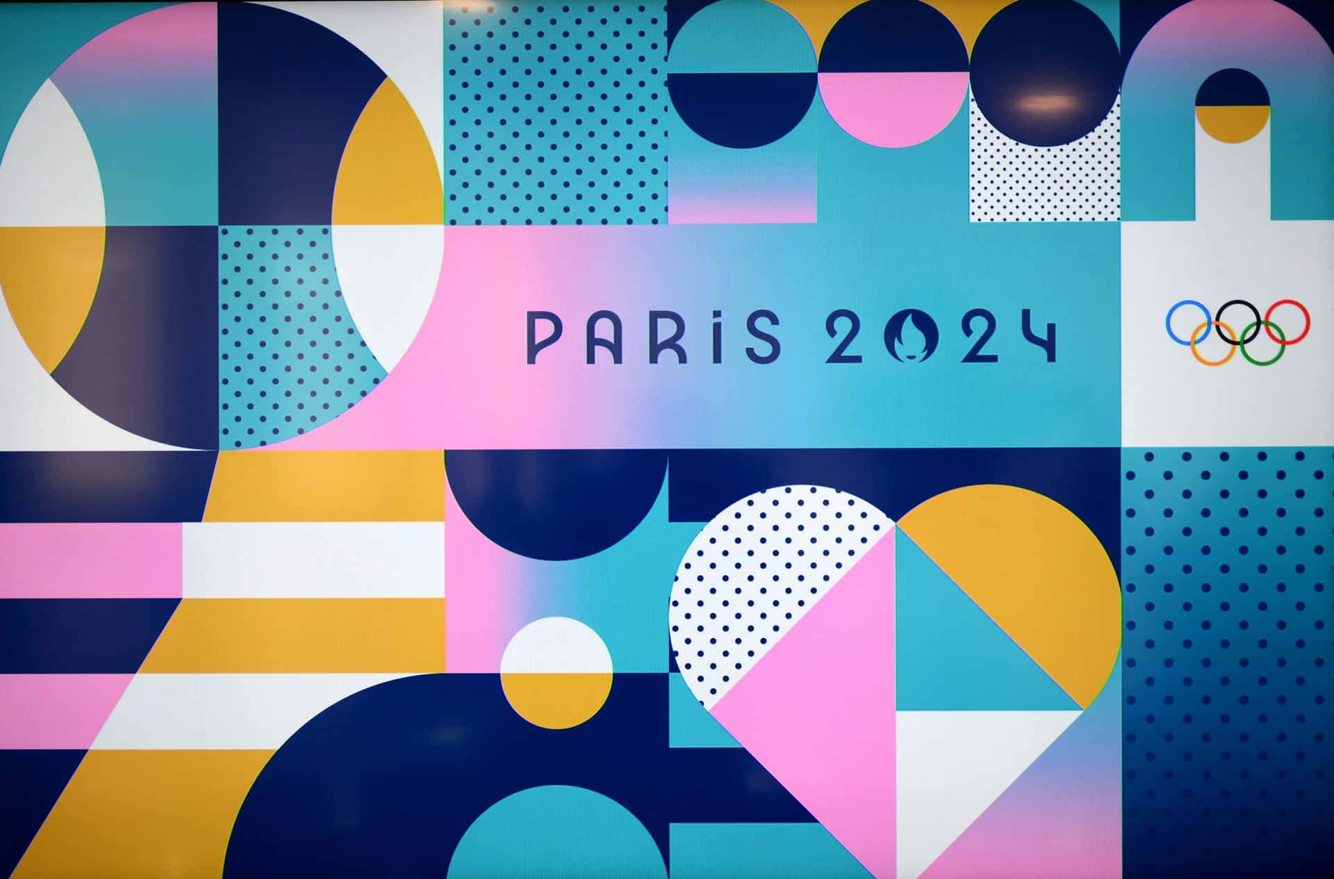  壁紙 — 為巴黎2024奧運會設計的充滿活力的幾何圖案牆藝，色彩大膽，形狀抽象。