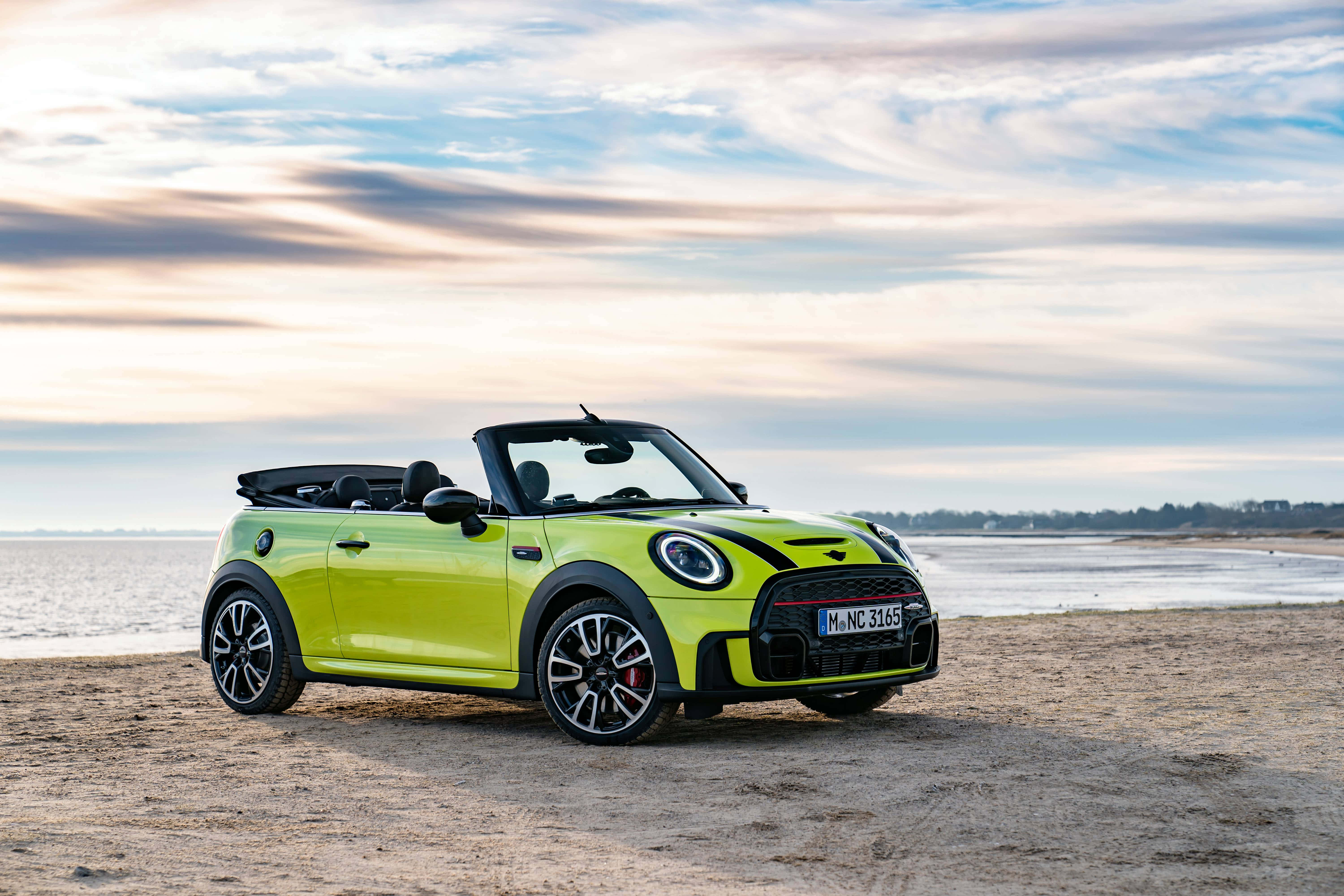 Mini Cooper Convertible 桌布 壁紙 — 一輛充滿活力的青檸綠色MINI開篷車在日落時分停泊在沙灘上，天空呈現柔和粉彩色調。