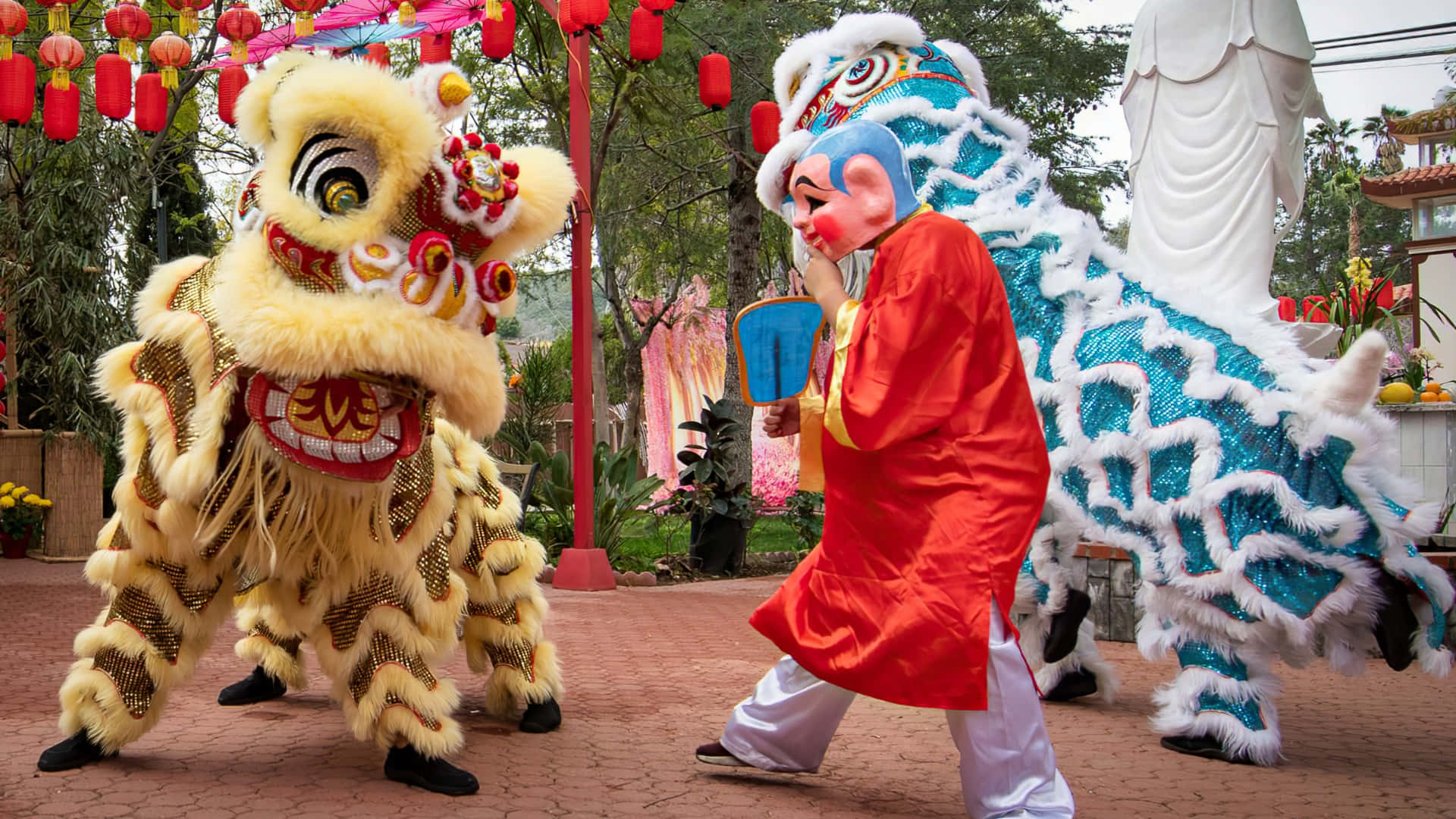  壁紙 — 充滿活力的舞獅表演者身穿金色和藍色服裝，在紅色燈籠下於節日庭院中充滿活力地表演。