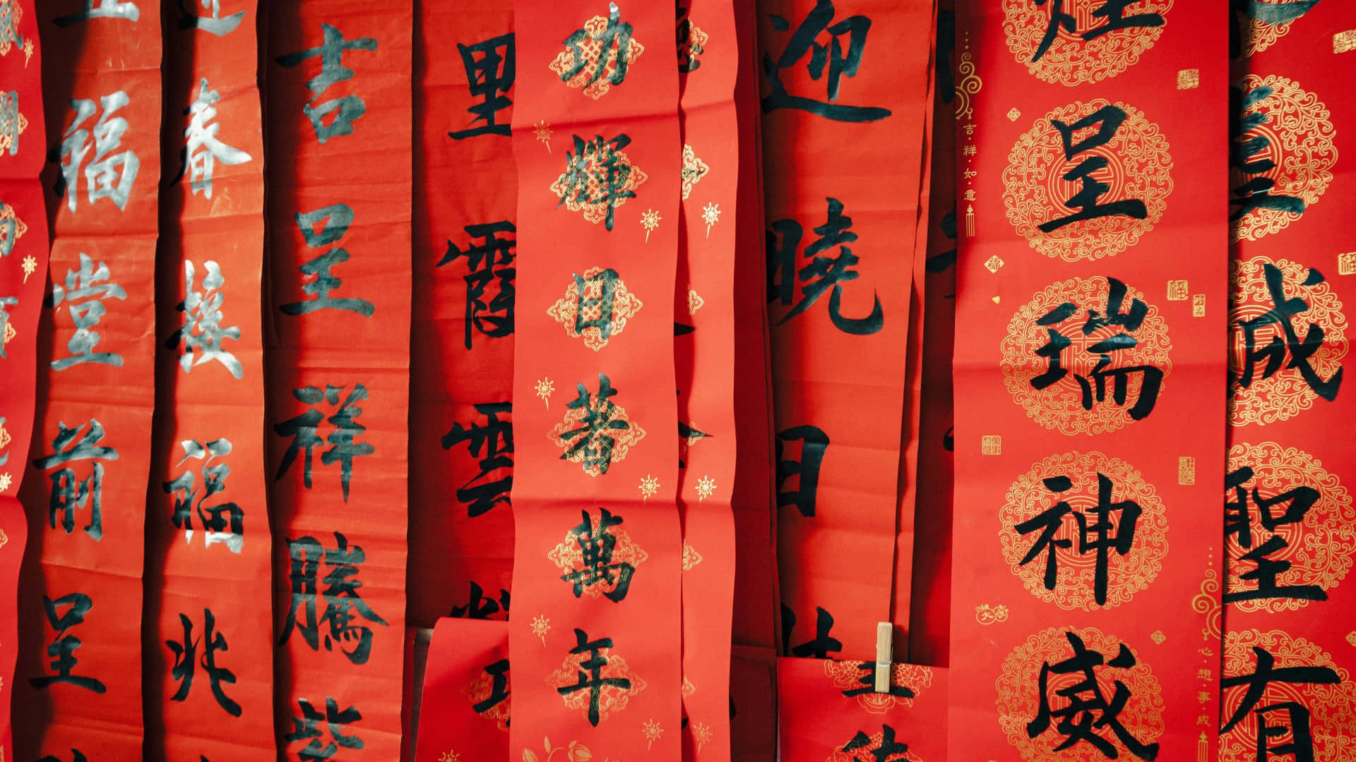  壁紙 — 鮮豔的紅色中國春聯，帶有黑色書法和金色點綴，緊密地掛在一起，呈現節日氣氛。