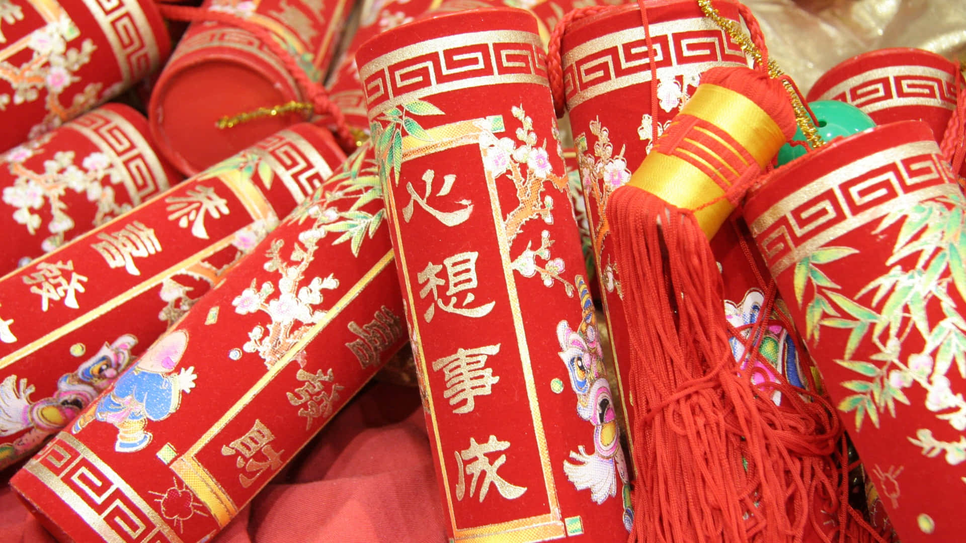  壁紙 — 鮮豔的紅色鞭炮飾有金色中文字和花卉圖案，堆成喜慶的一堆。