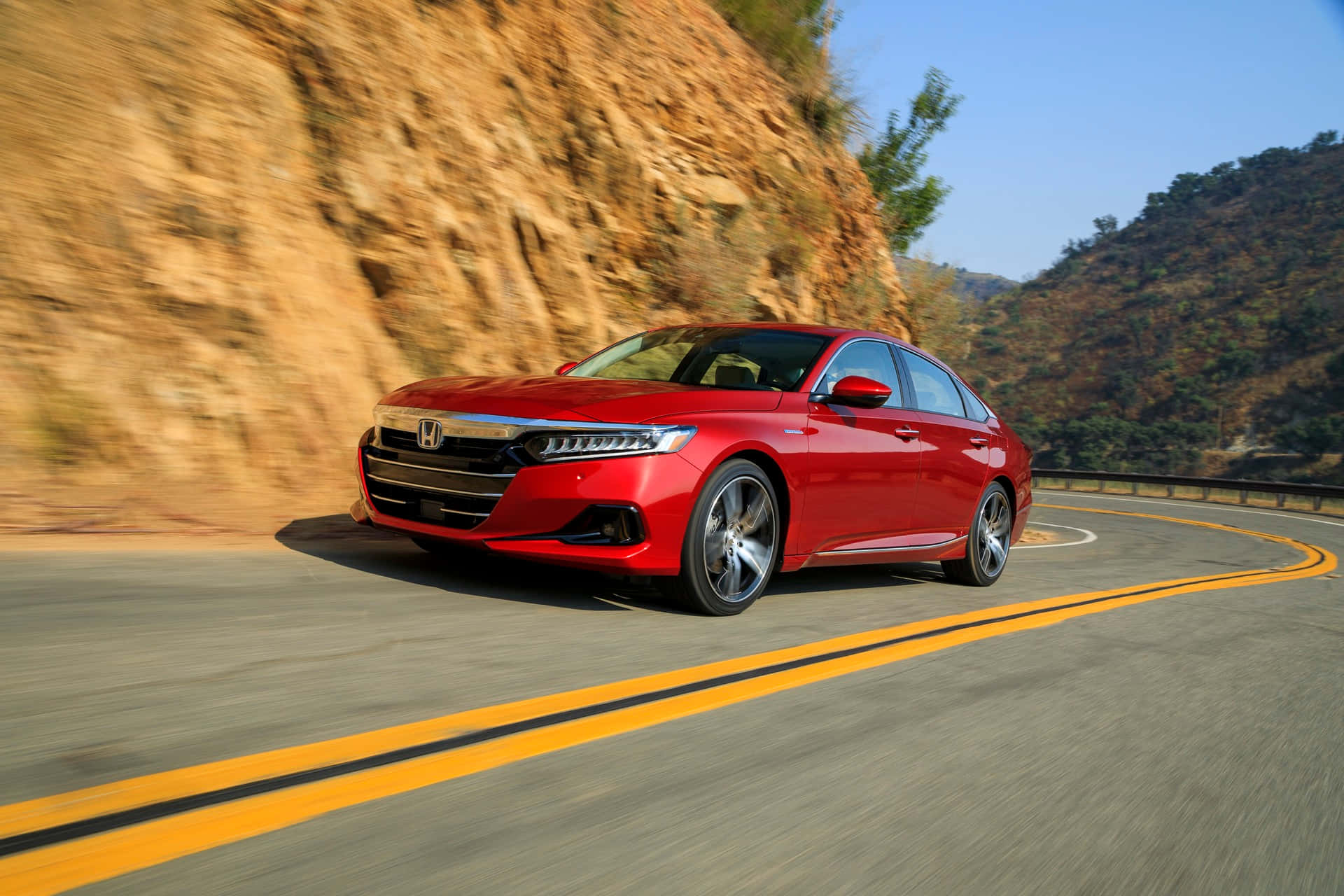 Honda Accord 桌布 壁紙 — 一輛鮮紅色的本田房車沿著蜿蜒的山路疾馳，旁邊是岩石峭壁，帶有模糊的動感。