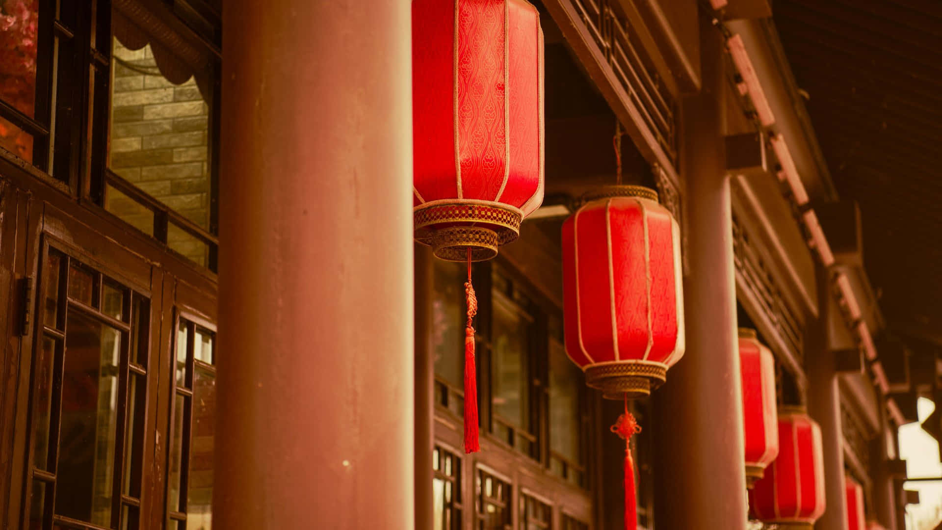  壁紙 — 鮮豔的紅色燈籠在夜間溫暖地發光，懸掛在傳統木建築前。