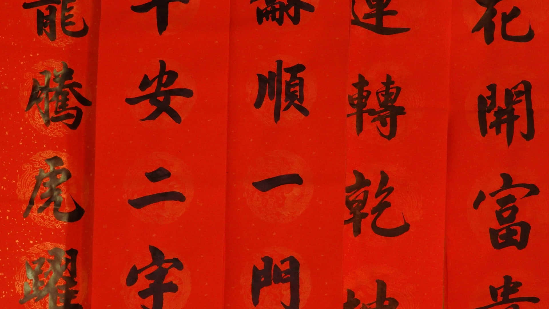  壁紙 — 鮮豔的紅紙上飾有粗體黑色中文書法字，傳達節日祝福。