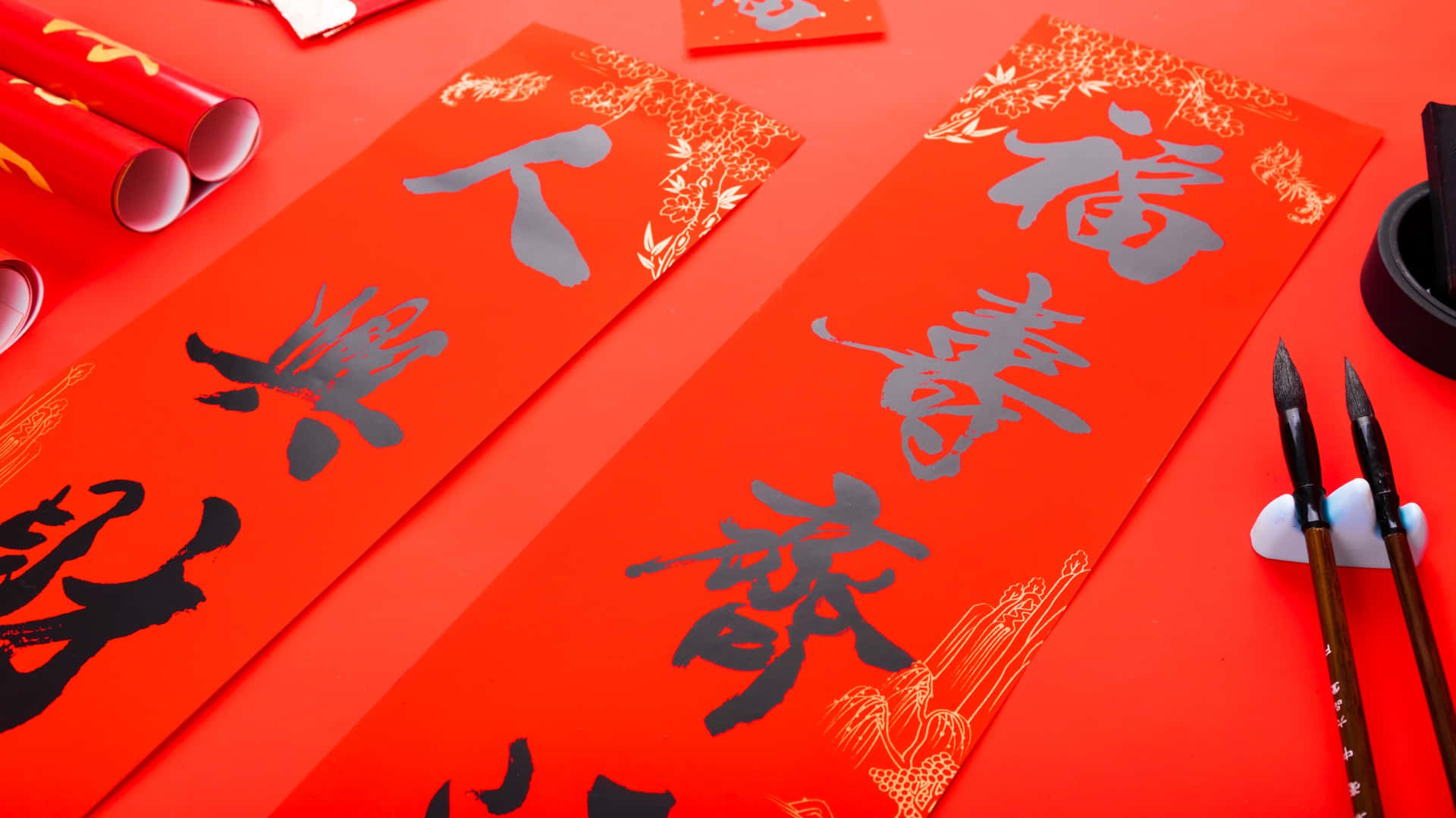  壁紙 — 鮮豔的紅紙上帶有優雅的黑色中國書法和金色點綴，為農曆新年慶祝而佈置。