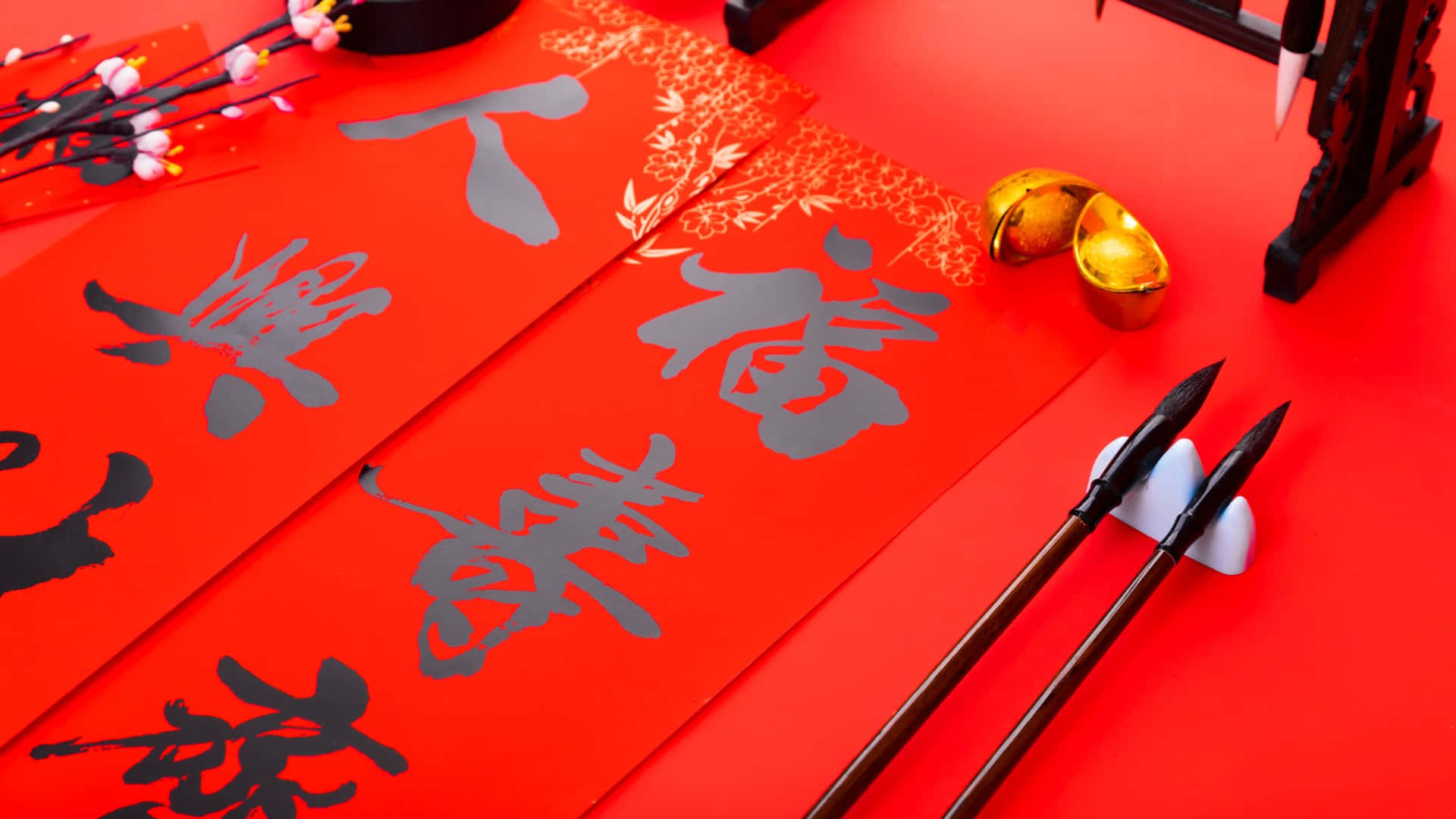  壁紙 — 鮮豔的紅紙上帶有優雅的中國書法和金元寶，為農曆新年慶祝而佈置。