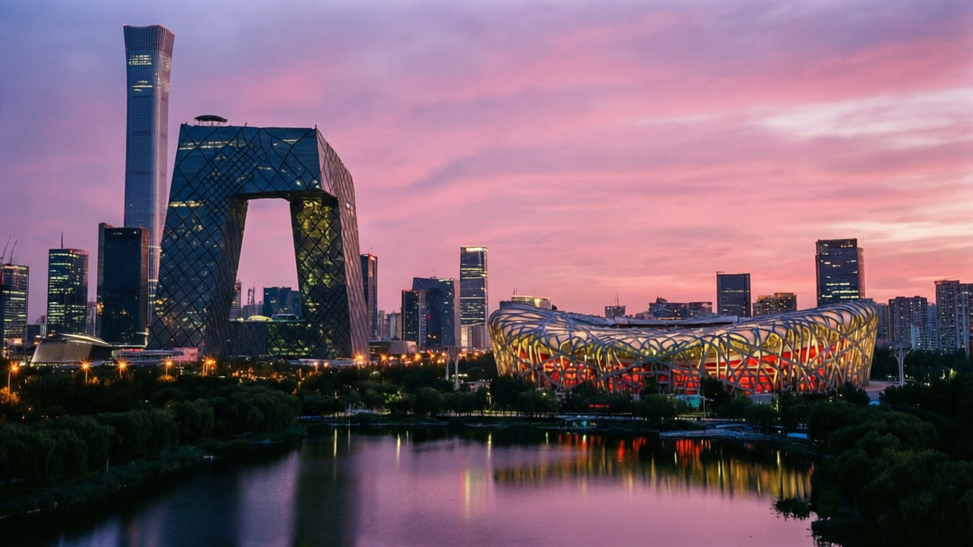 Beijing Skyline at Twilight 壁紙 — 充滿活力的夕陽以粉紅和紫色調描繪北京天際線，現代摩天大樓和標誌性體育館倒映在平靜的湖面上。