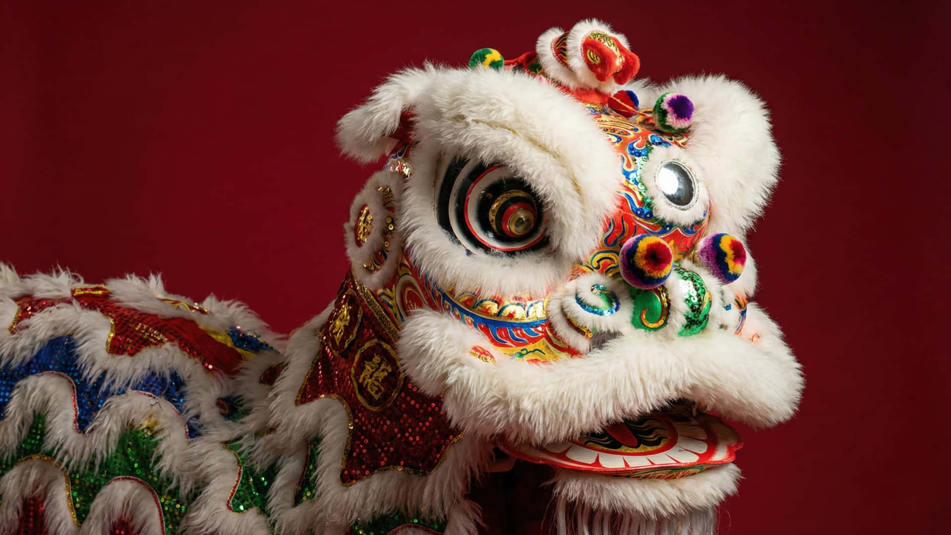  壁紙 — 一個充滿活力的傳統中國舞獅服裝，帶有蓬鬆的白色毛皮和色彩繽紛的刺繡圖案，背景為深紅色。