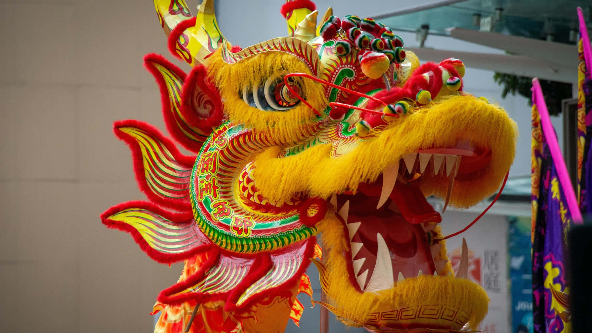  壁紙 — 色彩鮮豔的黃色和紅色中國舞龍服裝，帶有精緻刺繡和兇猛表情。