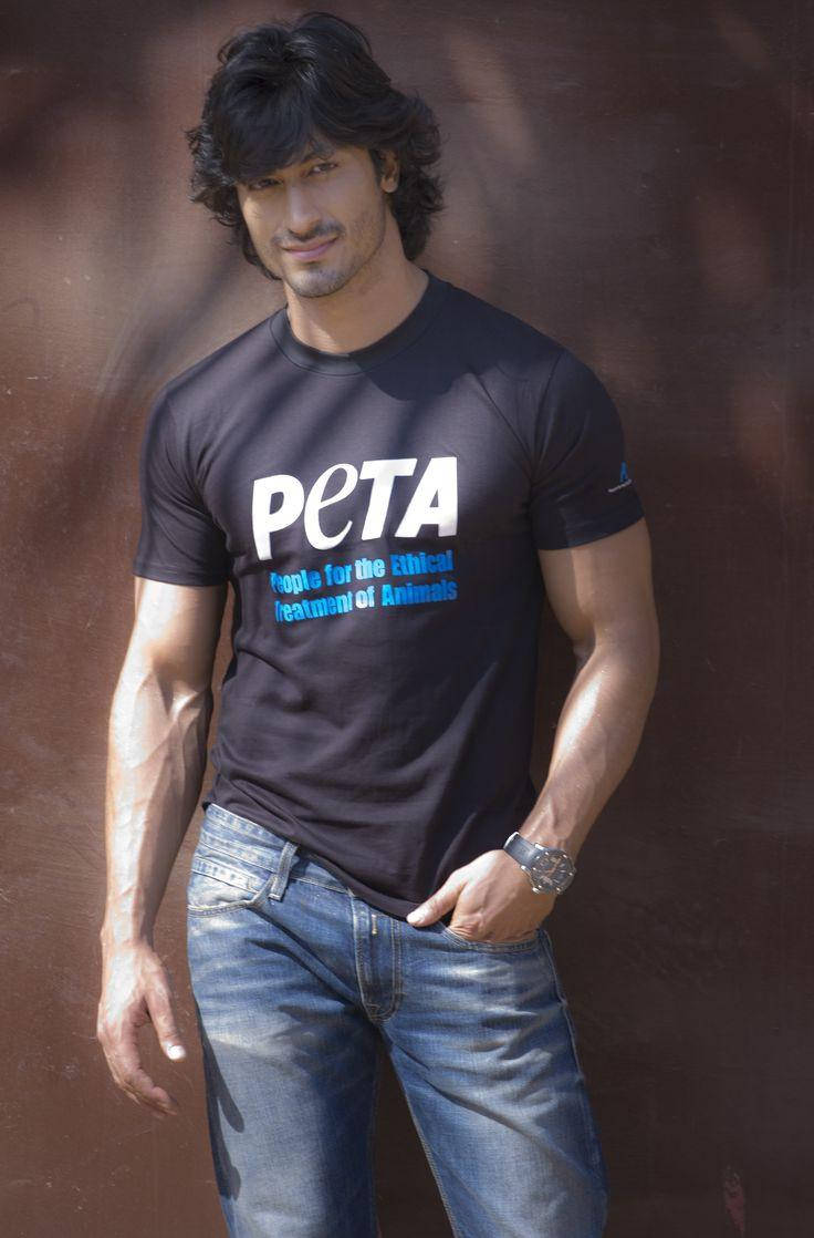 一名穿著PETA T恤和牛仔褲的男子靠著牆壁。