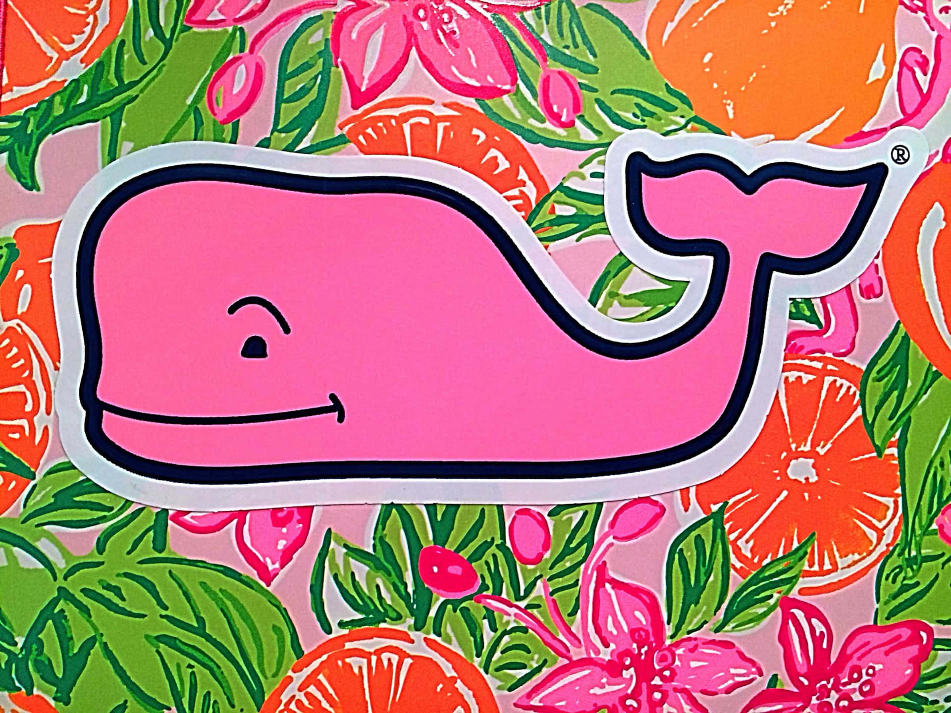 Vineyard Vines 鯨魚與花卉圖案 壁紙 — 一個帶黑色輪廓的開心粉紅色鯨魚貼紙，放在充滿活力的橙片和粉紅色花朵圖案上，襯以綠葉。