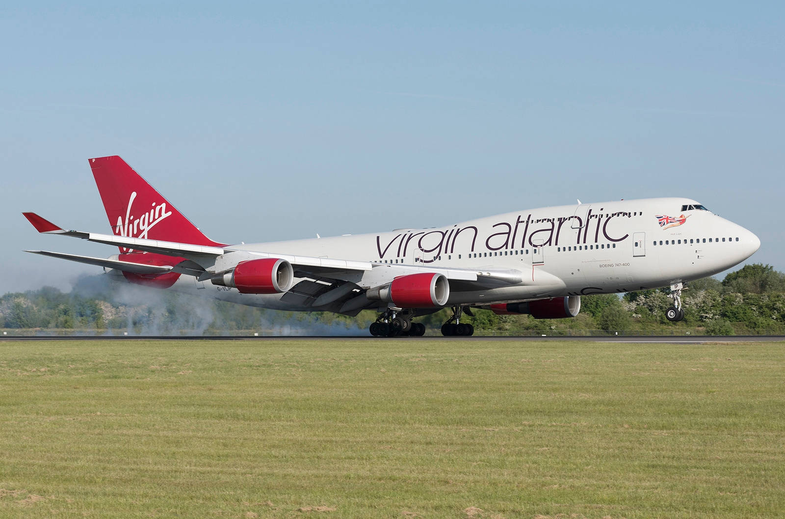 Virgin Atlantic航空飛機起飛 壁紙 — 維珍航空波音747在藍天白雲下，於有綠草和樹木的跑道上滑行。