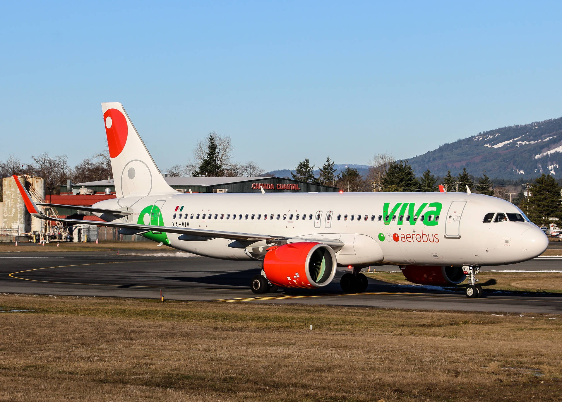 Viva Aerobus飛機在跑道上滑行，背景有山脈