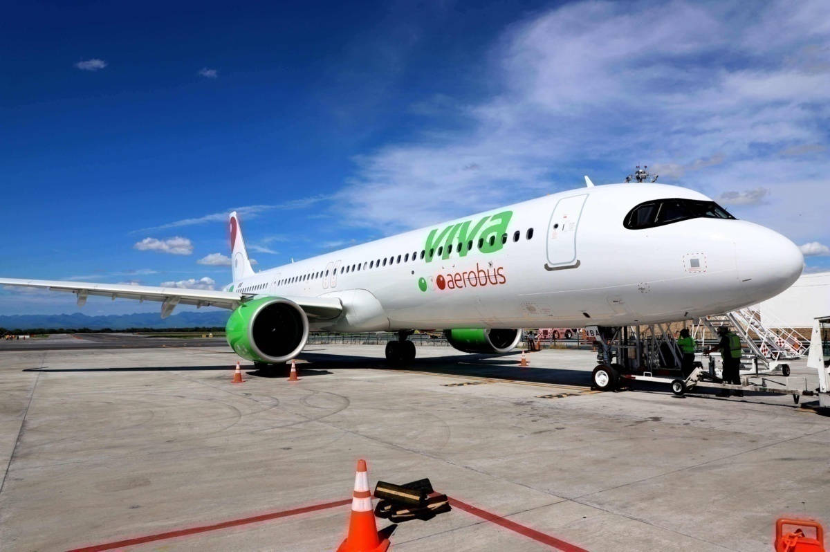 Viva Aerobus飛機停泊在機場停機坪，地面工作人員和橙色錐形標誌。