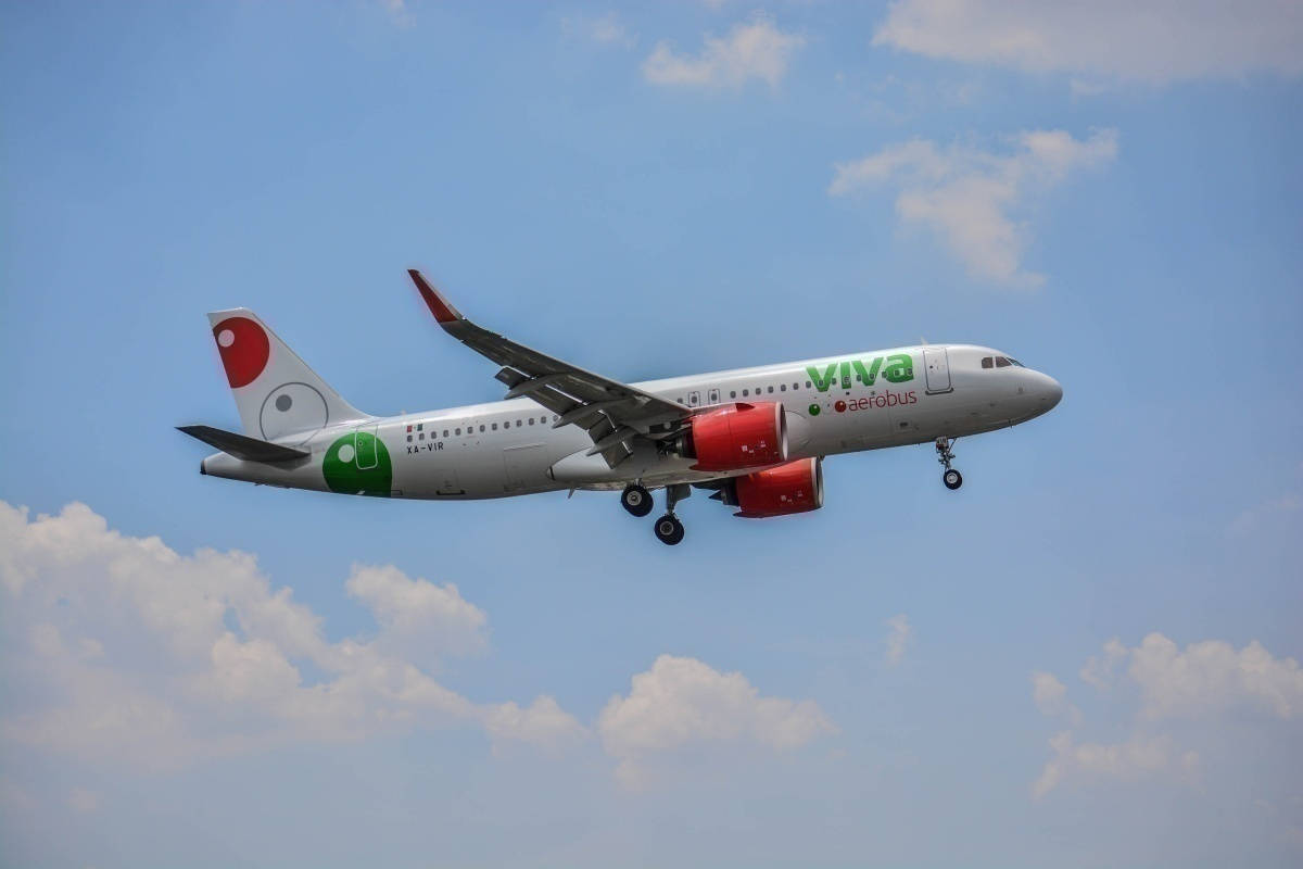 Viva Aerobus飛機在藍天下放下起落架飛行